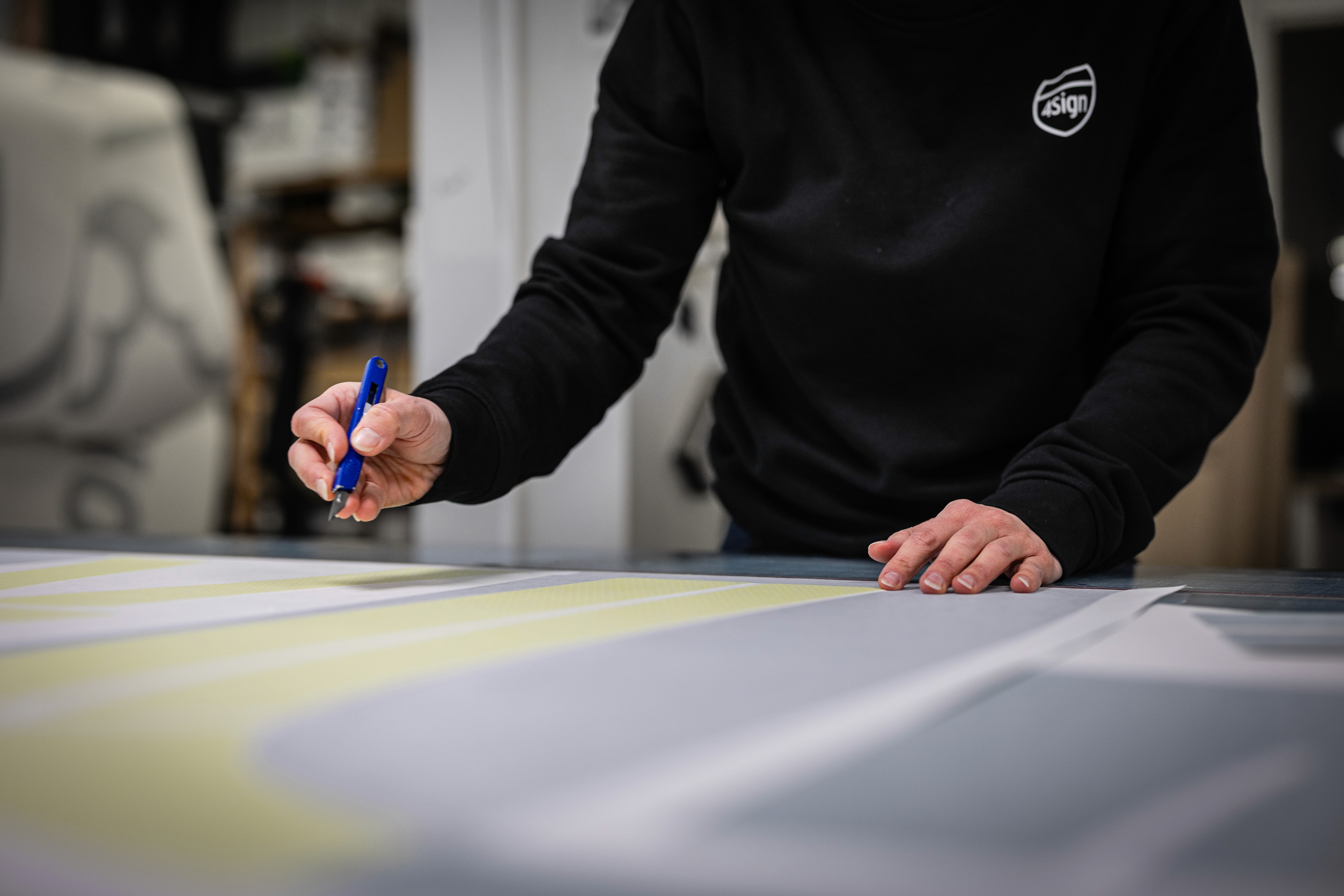 Kund granskar arbetskläder och varselkläder i 4Signs butik, brett utbud av profilprodukter.