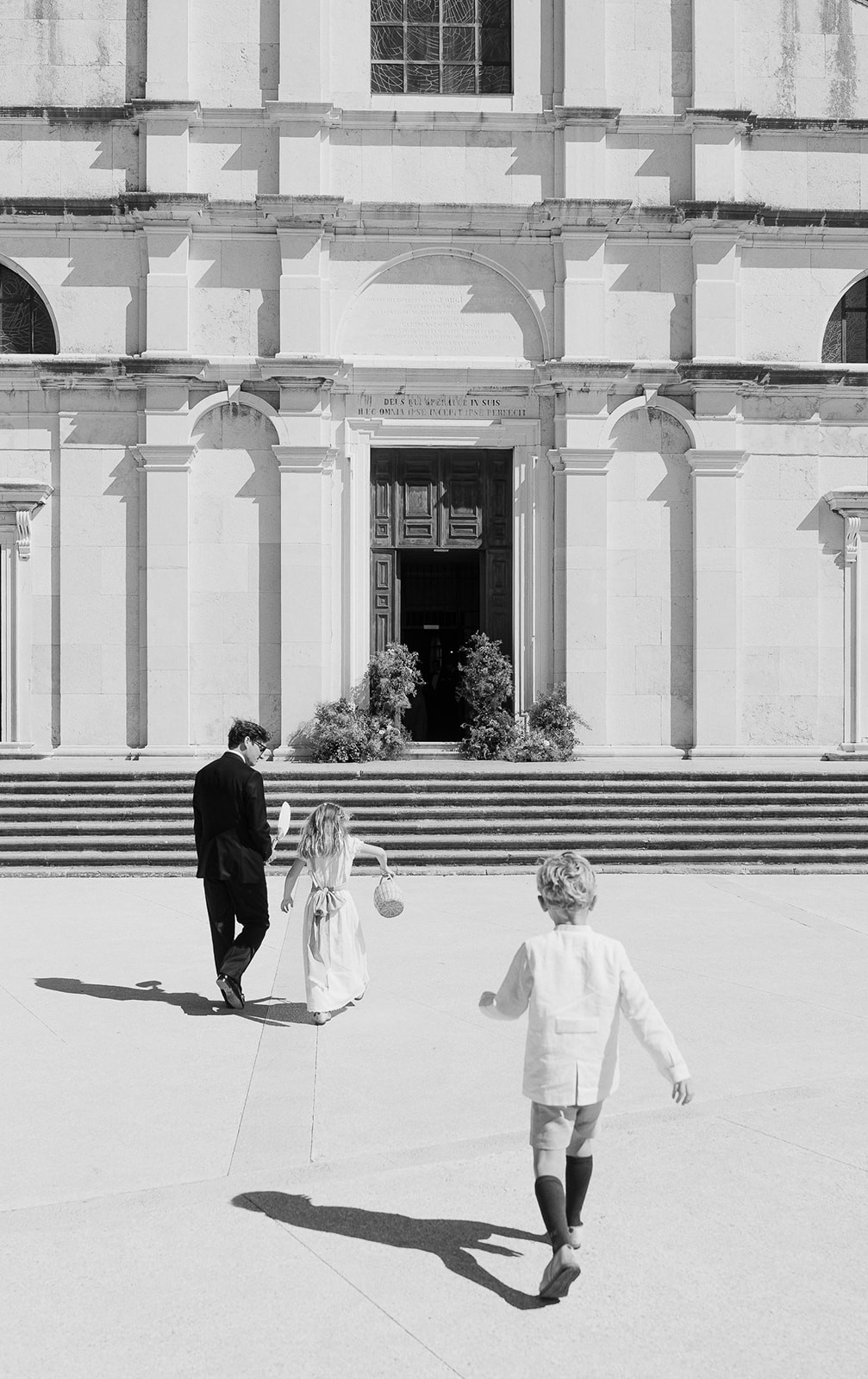 A scenic view of a garden with neatly trimmed hedges and trees, featuring a modern building in the background.
