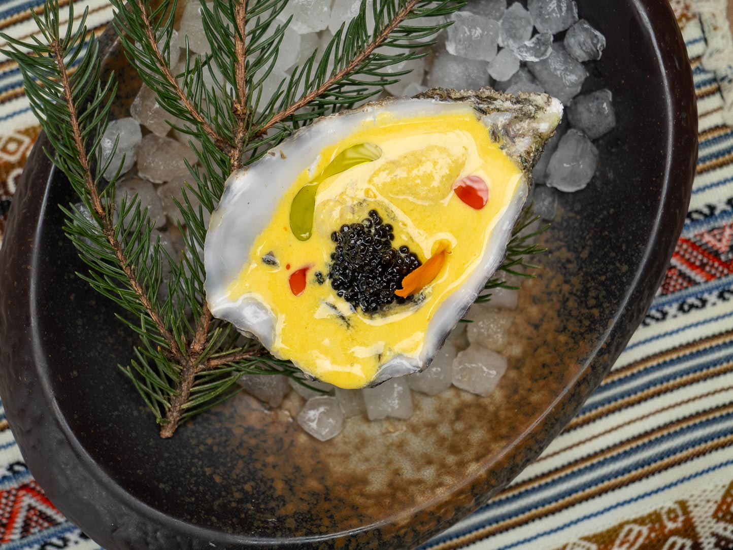 Ostra con leche de tigre y caviar sobre hielo