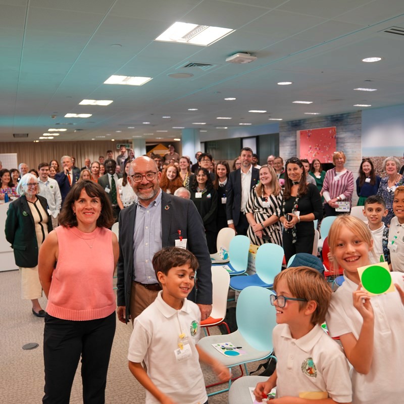 Photo of a reboot the future event with organisers and children smiling at the camera