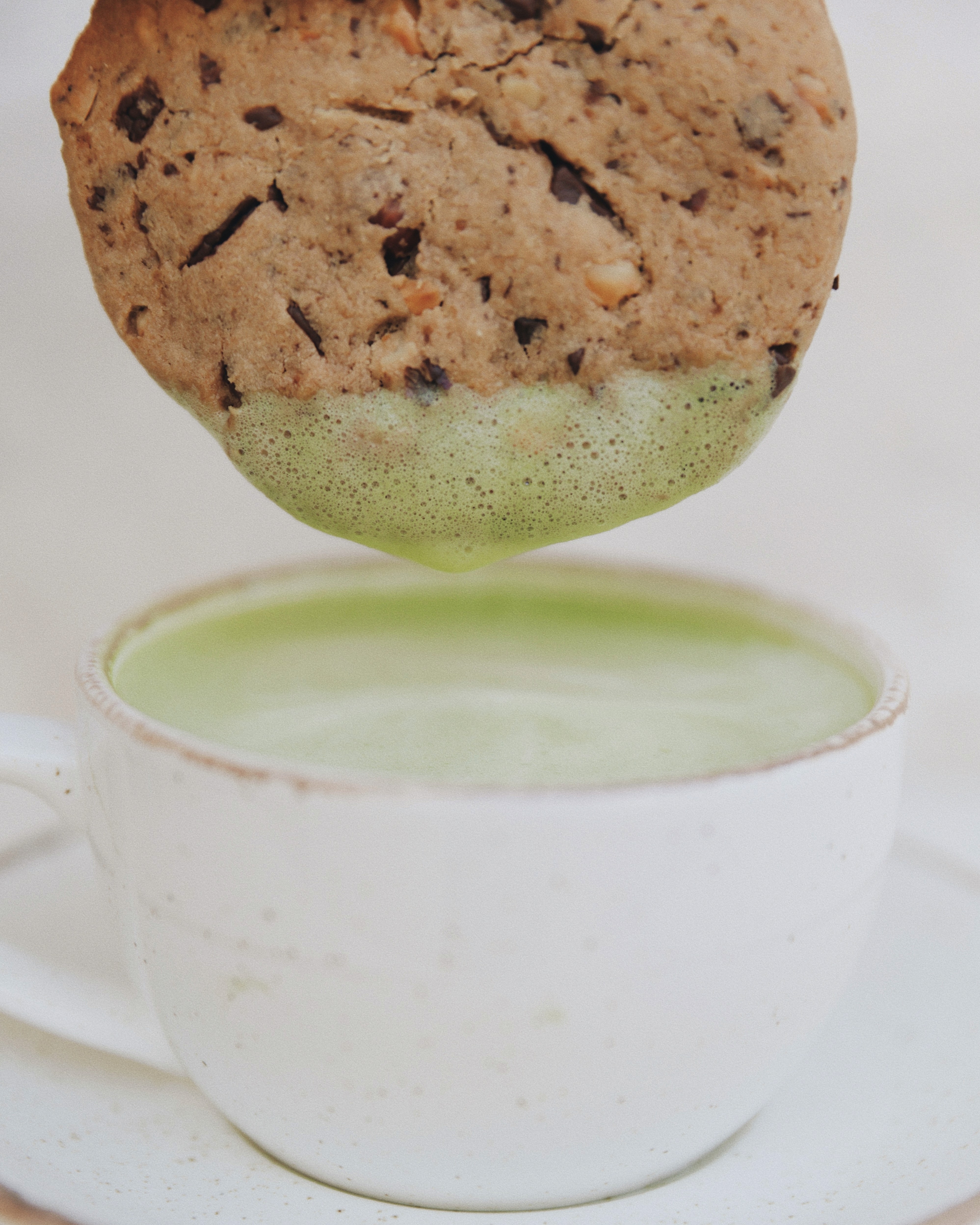 Soft matcha chocolate chip cookies on a ceramic plate and Matcha latte.