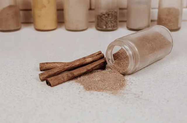 Cinnamon powder in bottle close  near brown cinnamon sticks