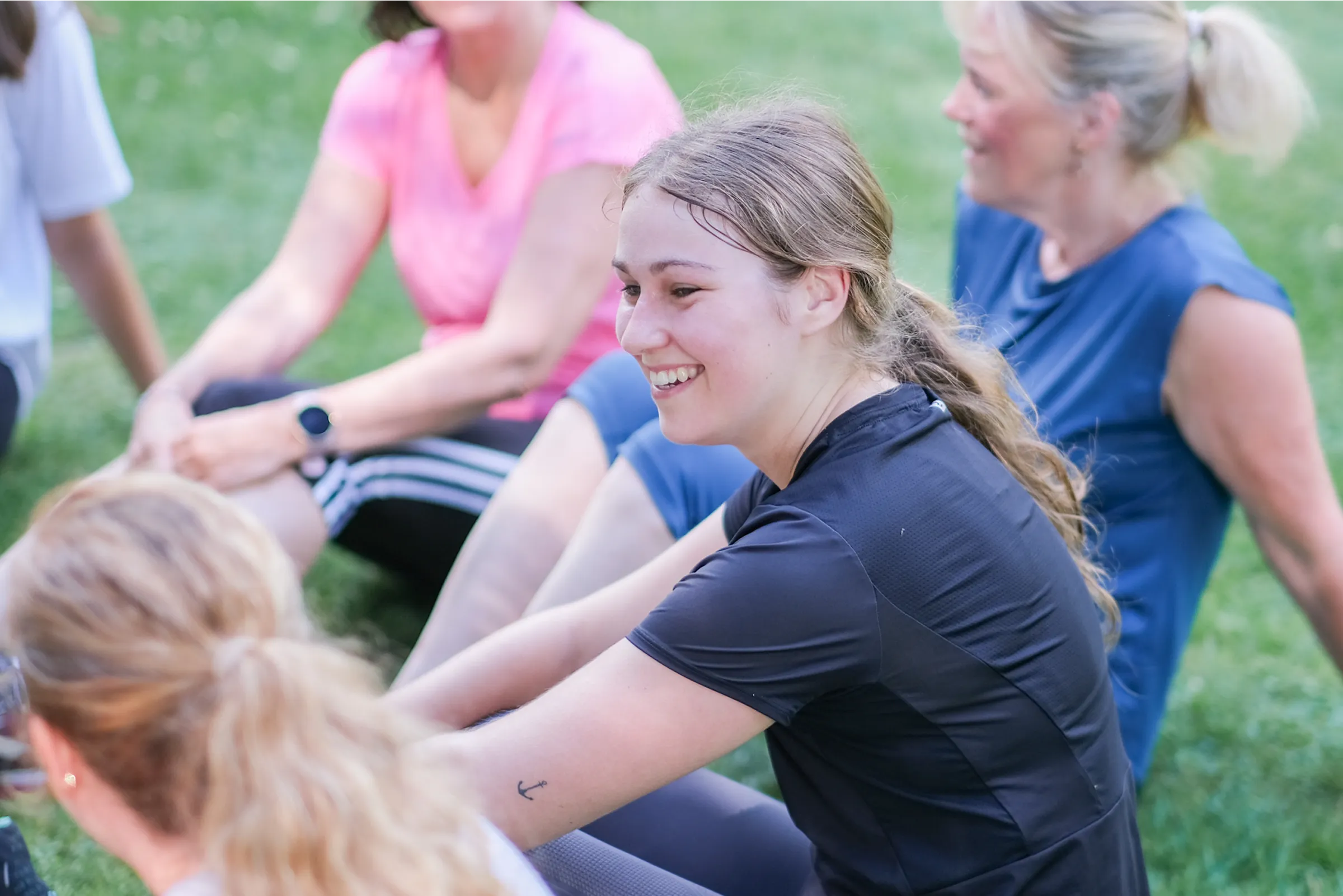 Gruppe sitzt nach Trainingseinheit auf dem Boden und bespricht die Fortschritte