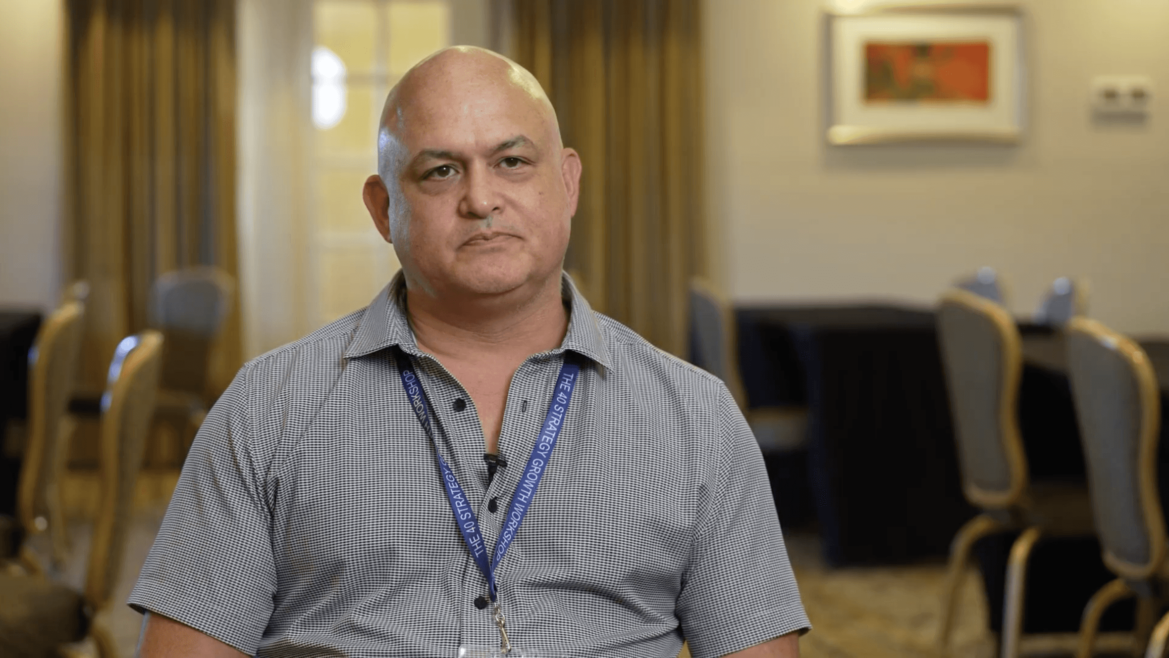 Man with beard in a red shirt smiling indoors