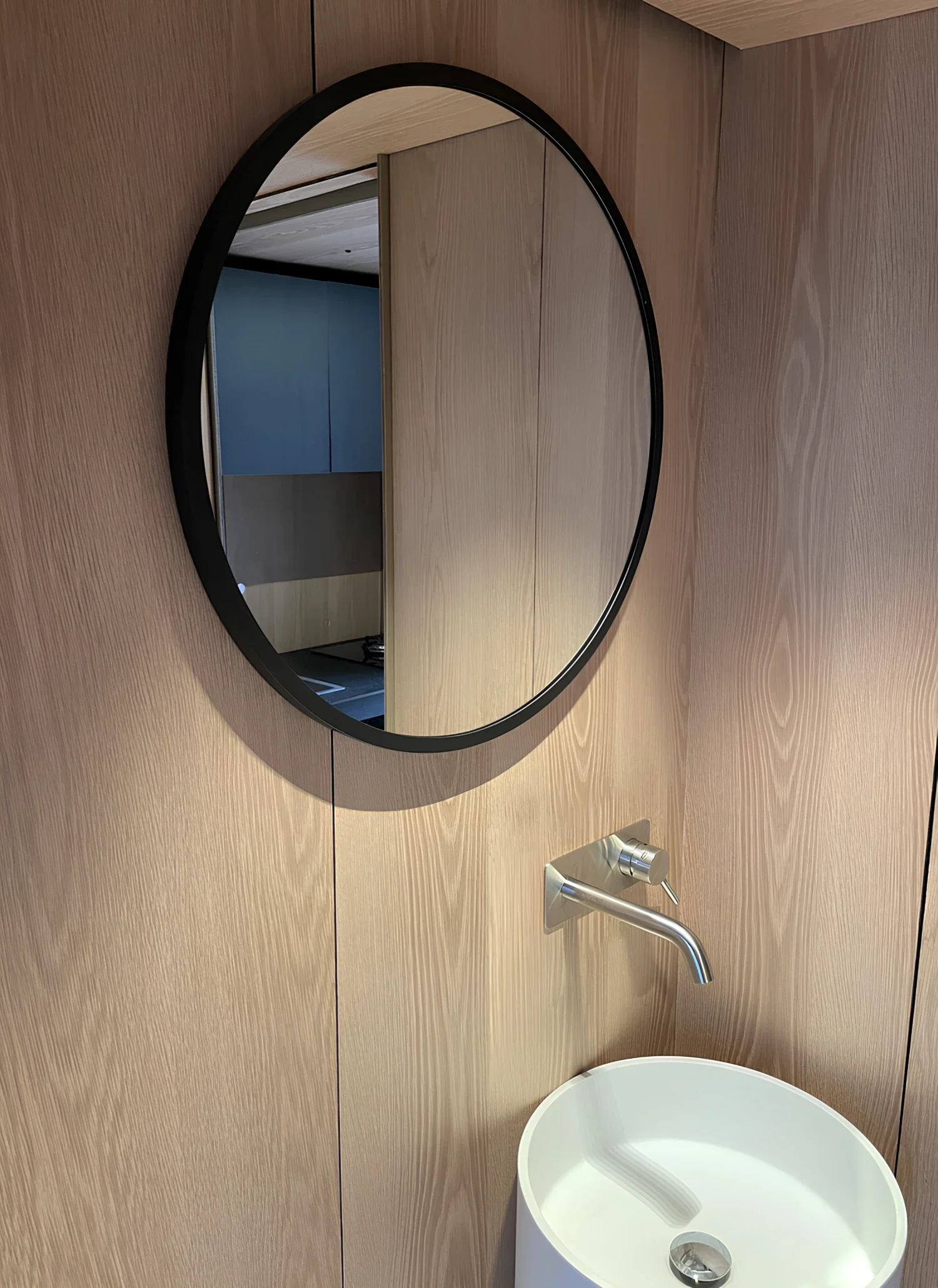Salle de bain de l'écolodge Villa Médicis, miroir rond et vasque sur habillage chêne