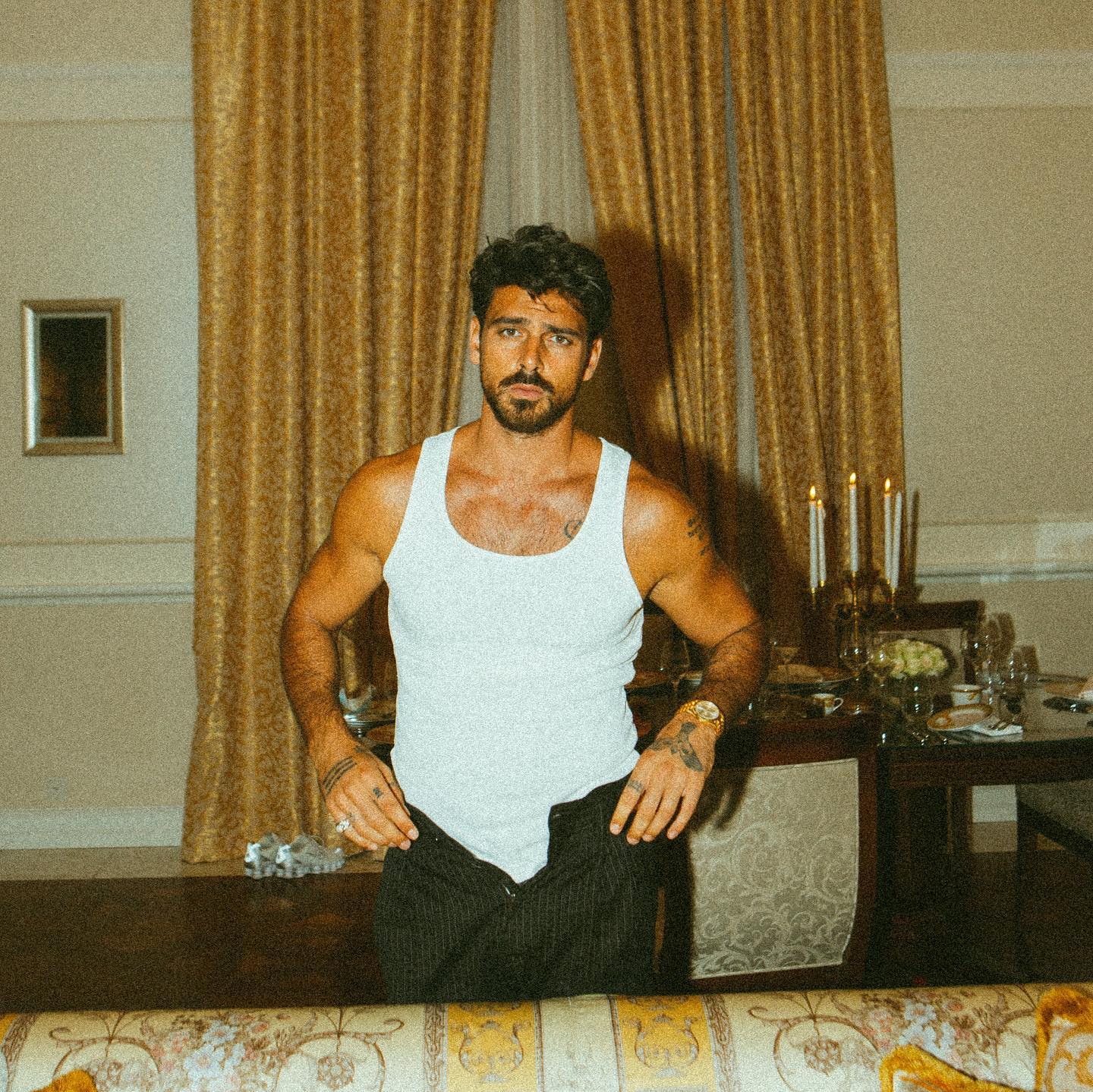 Black-and-white party photo of a smiling man in a check blazer among a crowd.