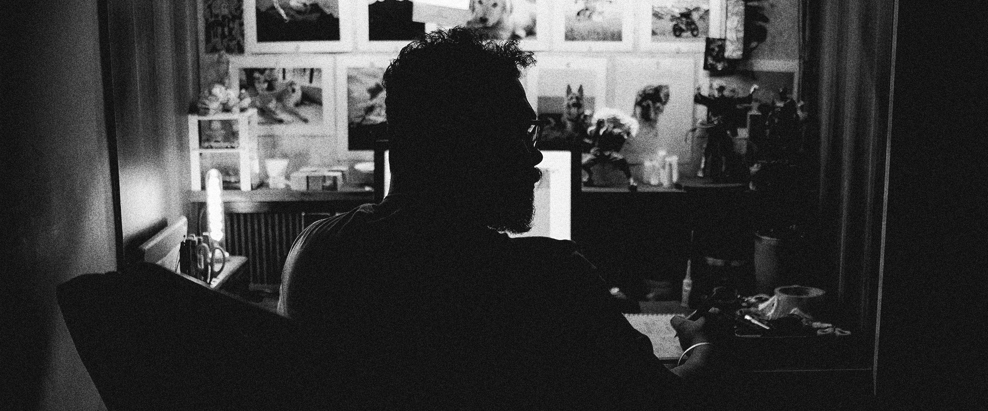 A close-up of a person wearing green-tinted glasses, with a serious expression and smooth skin.