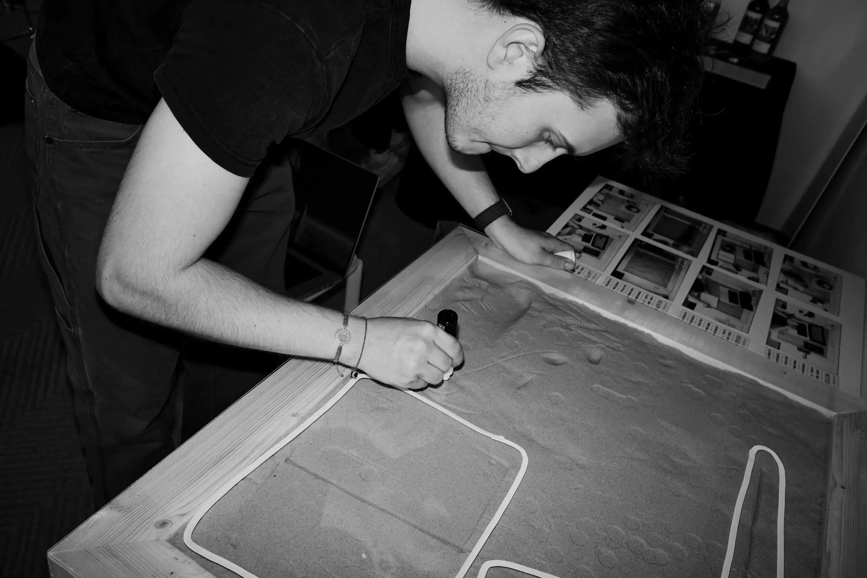 A person tracing outlines on the Tabula plaster surface with a marker