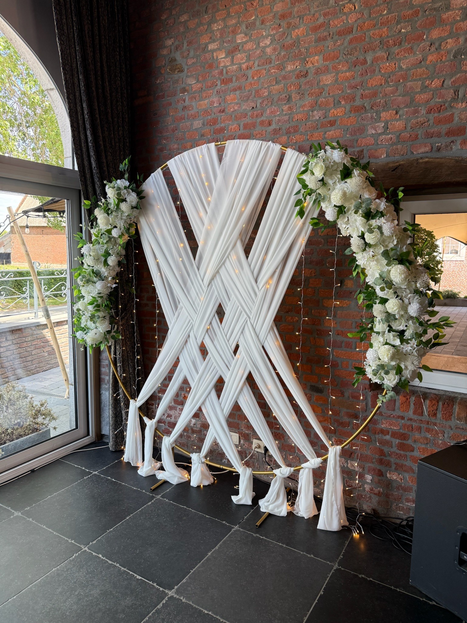Décor photomaton mariage avec arche ronde blanche et rubans décoratifs, installation élégante pour événement en Wallonie