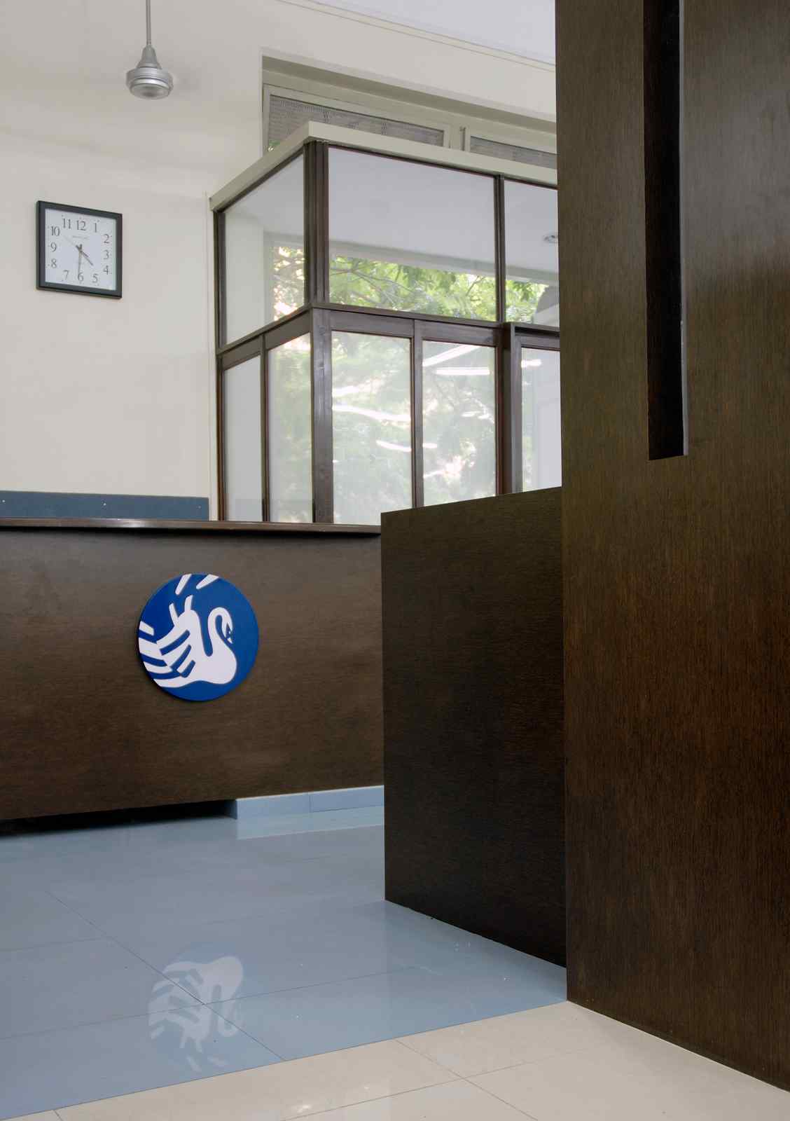 Nature-inspired preschool entrance with sculptural tree partitions and suspended green leaf ceiling panels.