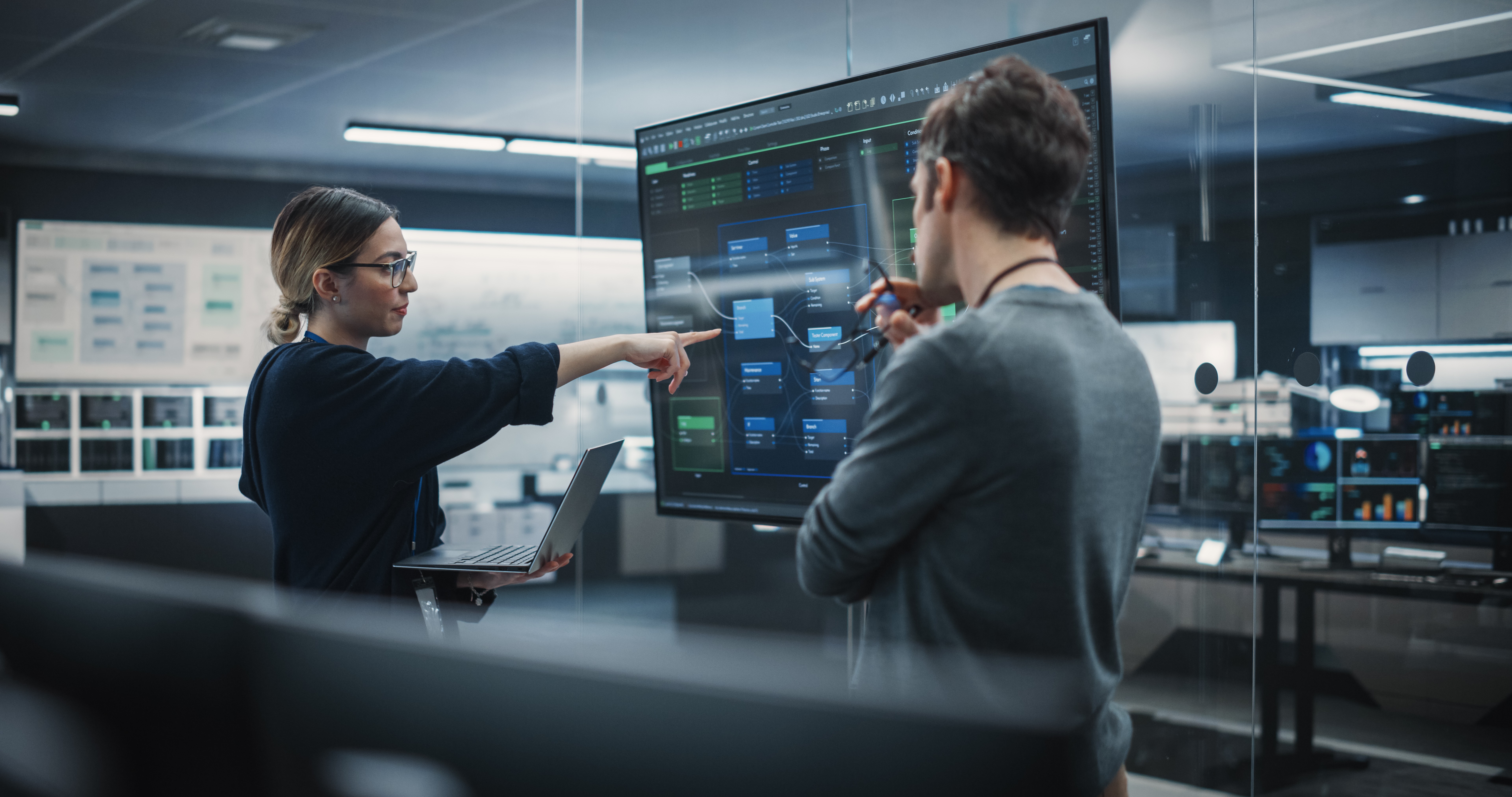 Auditor and AI system owner review governance evidence on a technical workflow during an AI management audit.