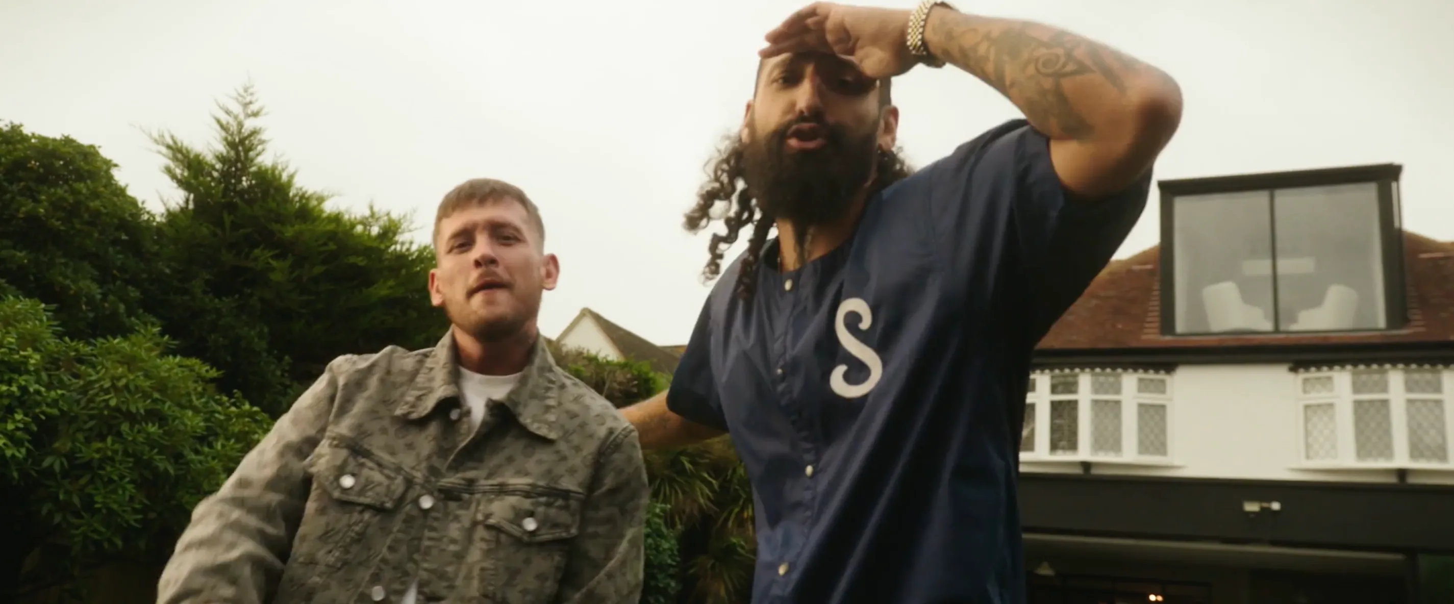 Two men posing outside and looking into a camera