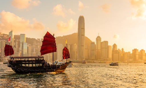 A maroon passport, a credit card, and a document are placed on a dark surface.