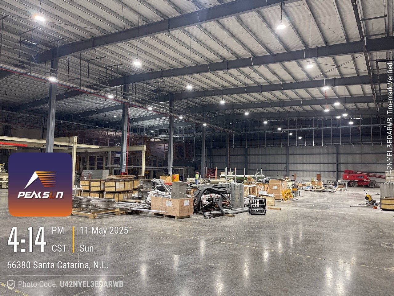 Large steel‑structure industrial factory workshop interior, overhead LED high‑bay lighting for manufacturing plant