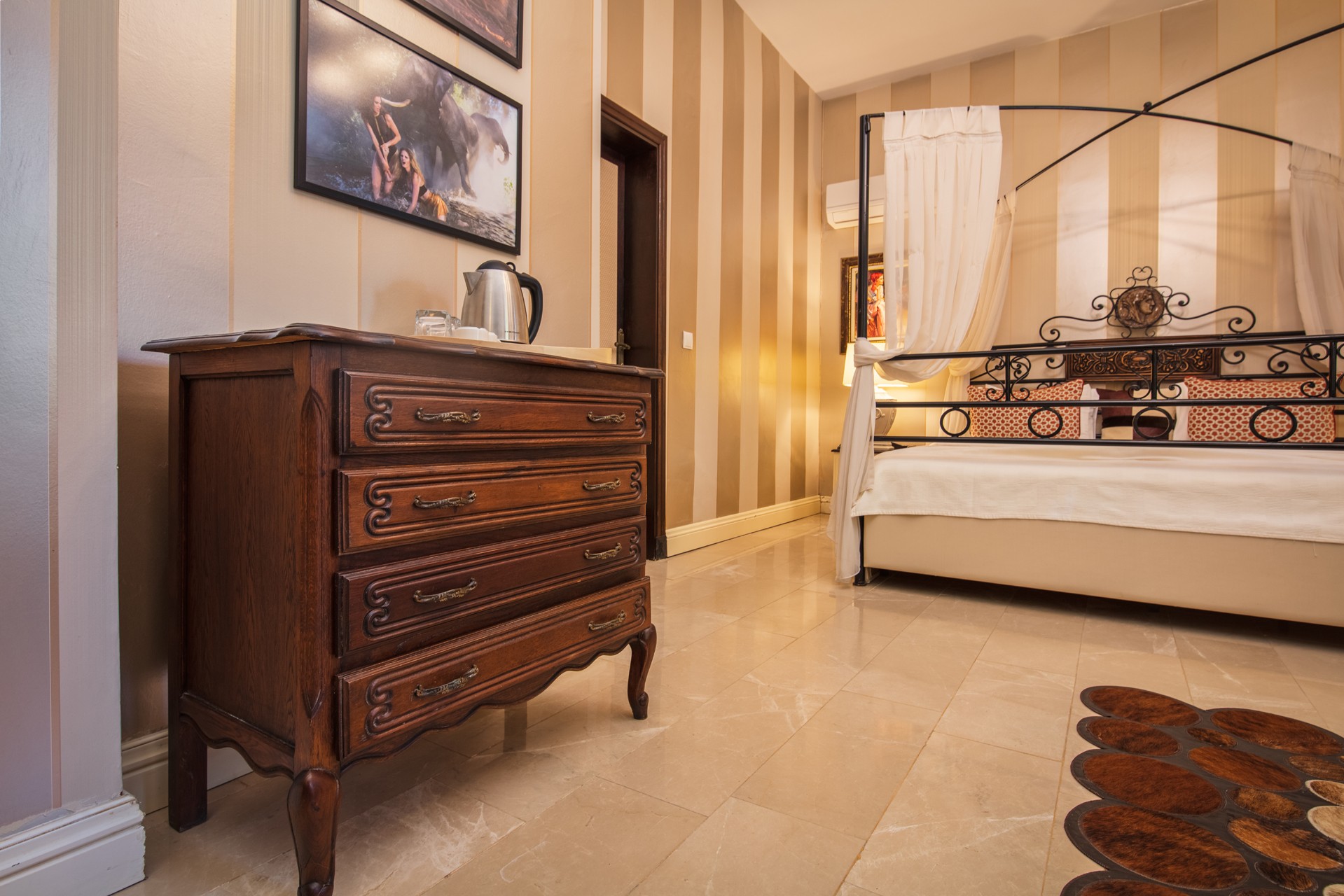 crisp white bedding, layered pillows, a plush bench at the foot of the bed