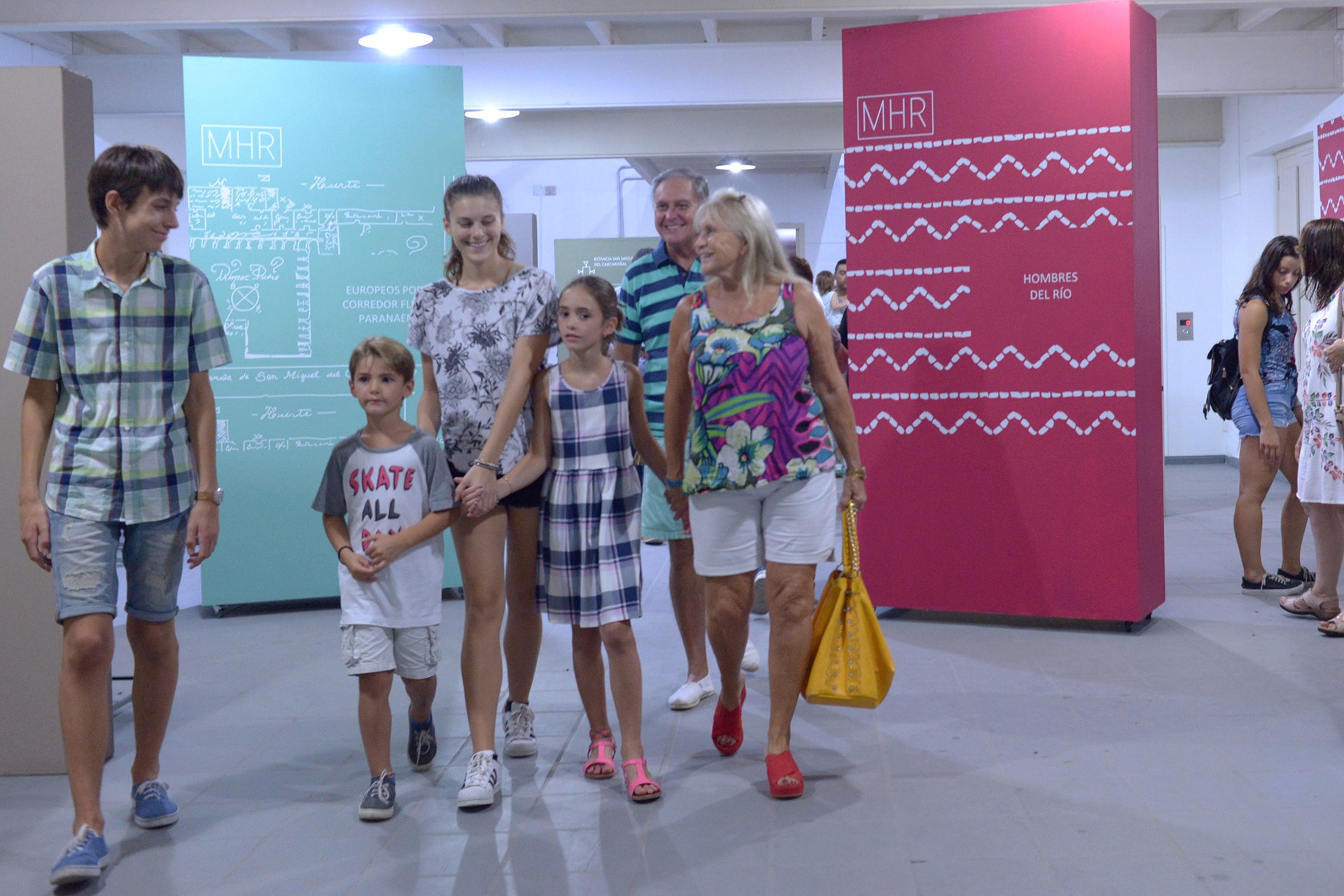 Black and white photo of two people looking at a computer screen with papers on wall