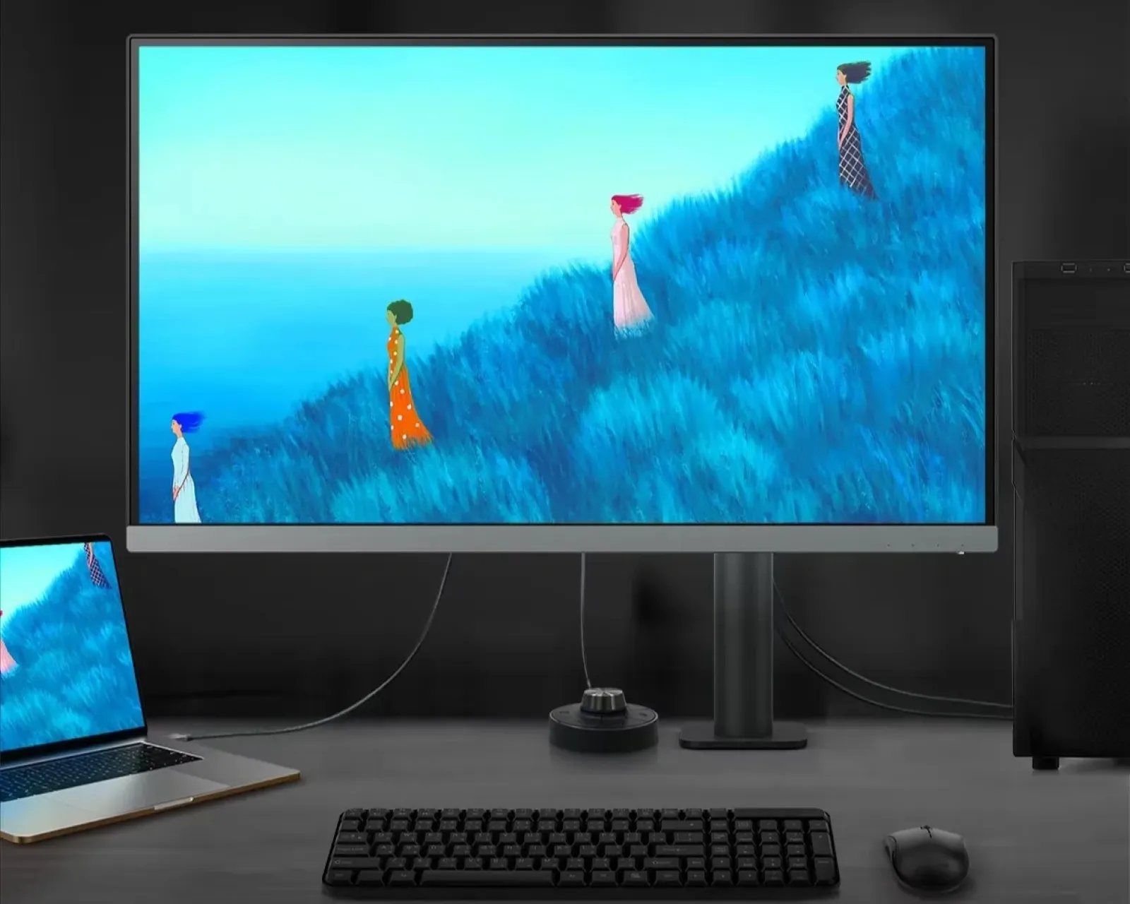 A modern computer monitor, displaying a digital art scene of people in colourful outfits walking up a grassy hill, sits on a desk alongside a laptop and keyboard.