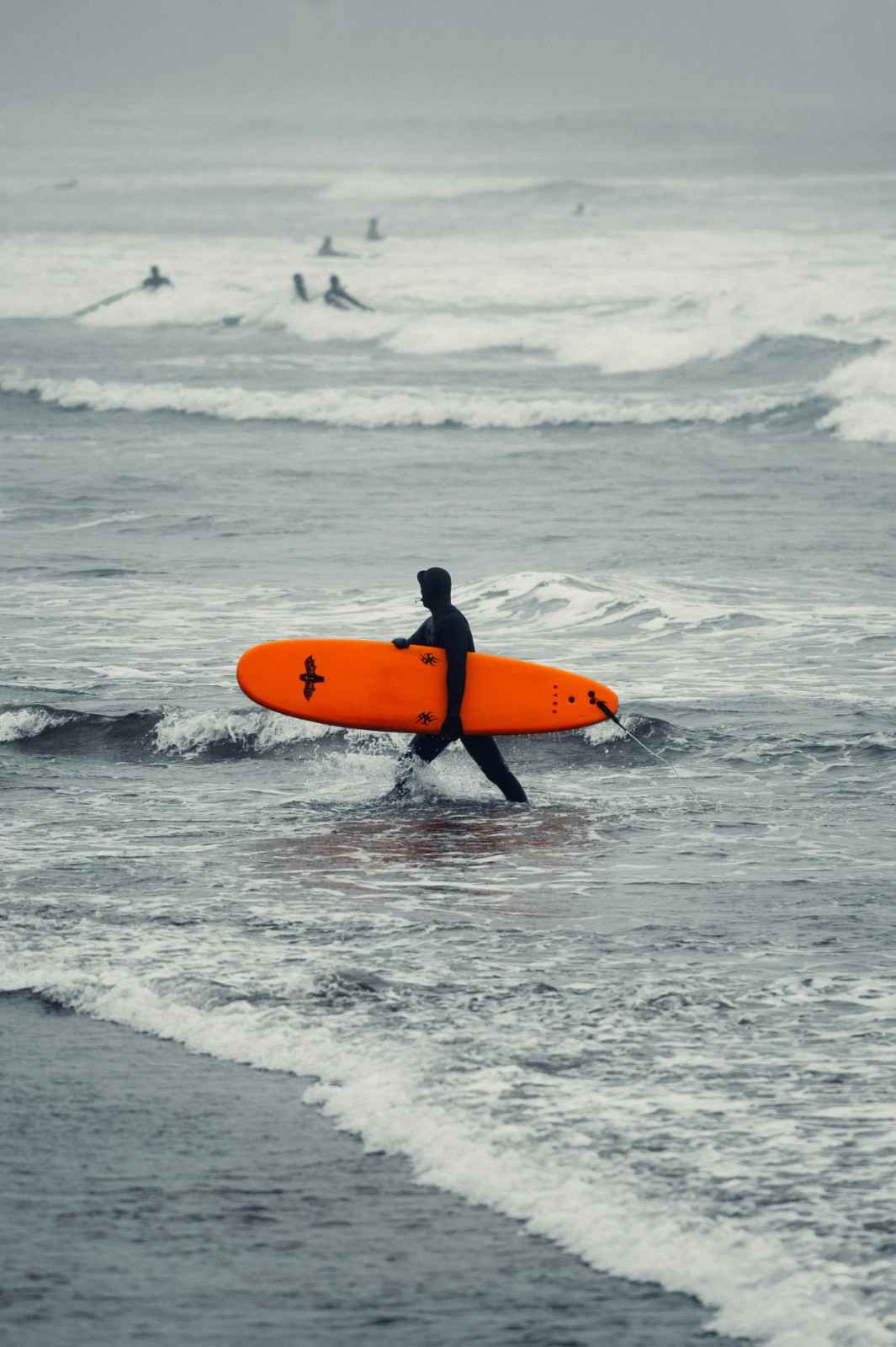 Surfer carrying board on shore – surfboard rental in Canada