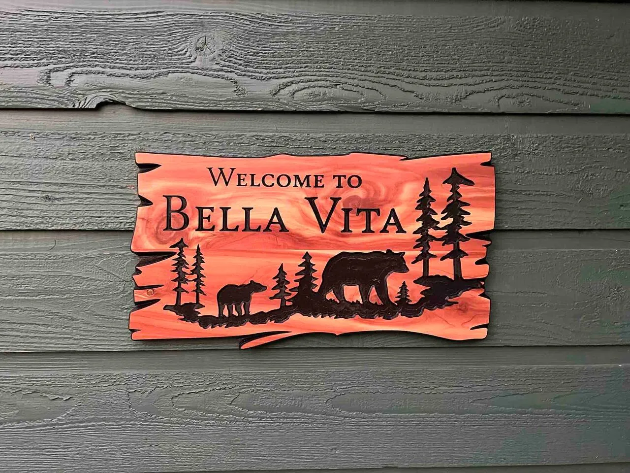 Carved Welcome to Bella Vita sign with bears and pines