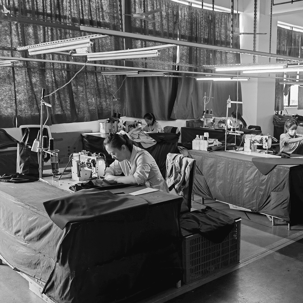 Skilled factory technicians sewing high-quality upholstery for ergonomic office chairs. This image highlights the handcrafted attention to detail and professional textile production within an industrial furniture factory