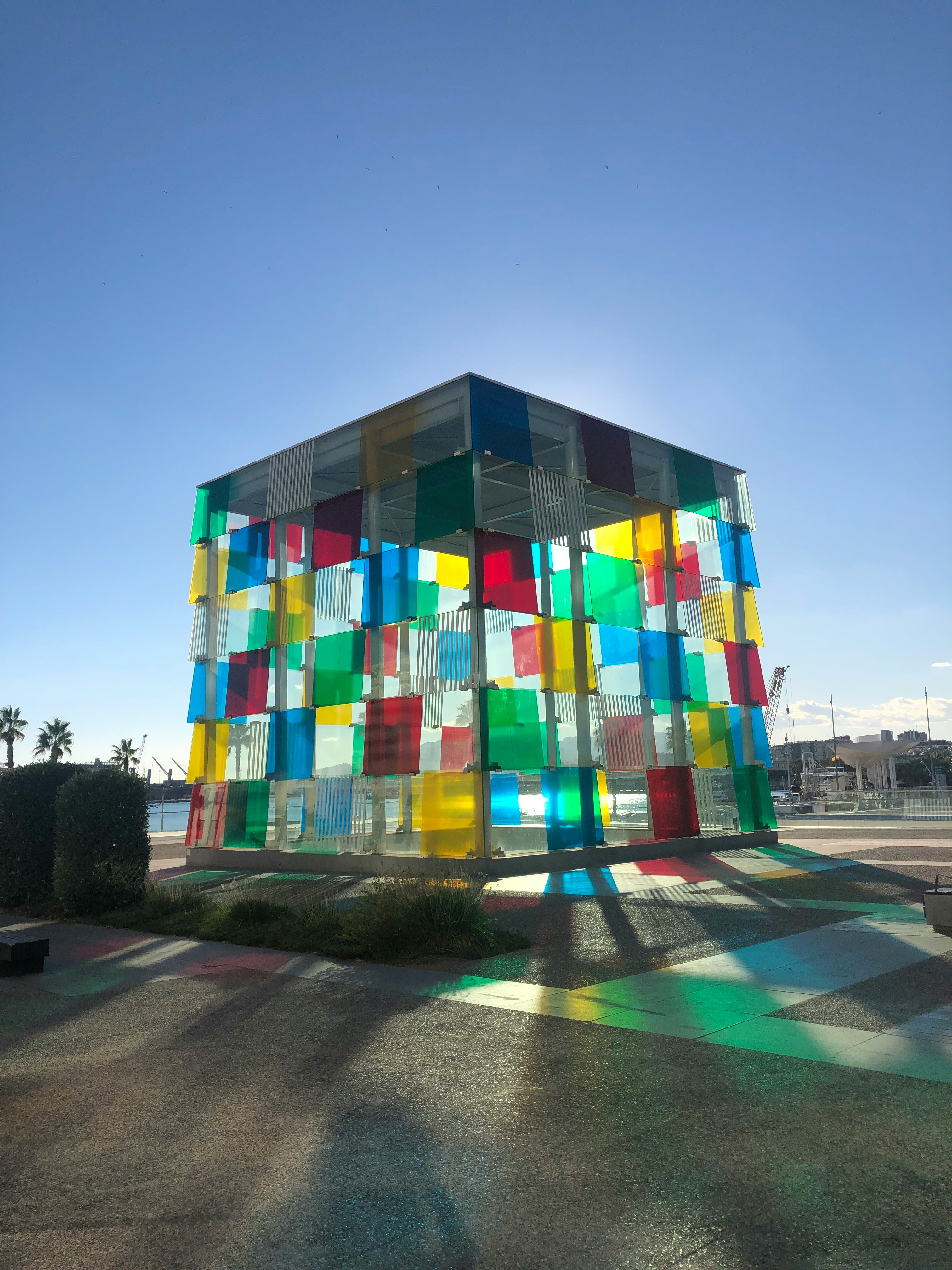 a multicolored building sits in the middle of a parking lot