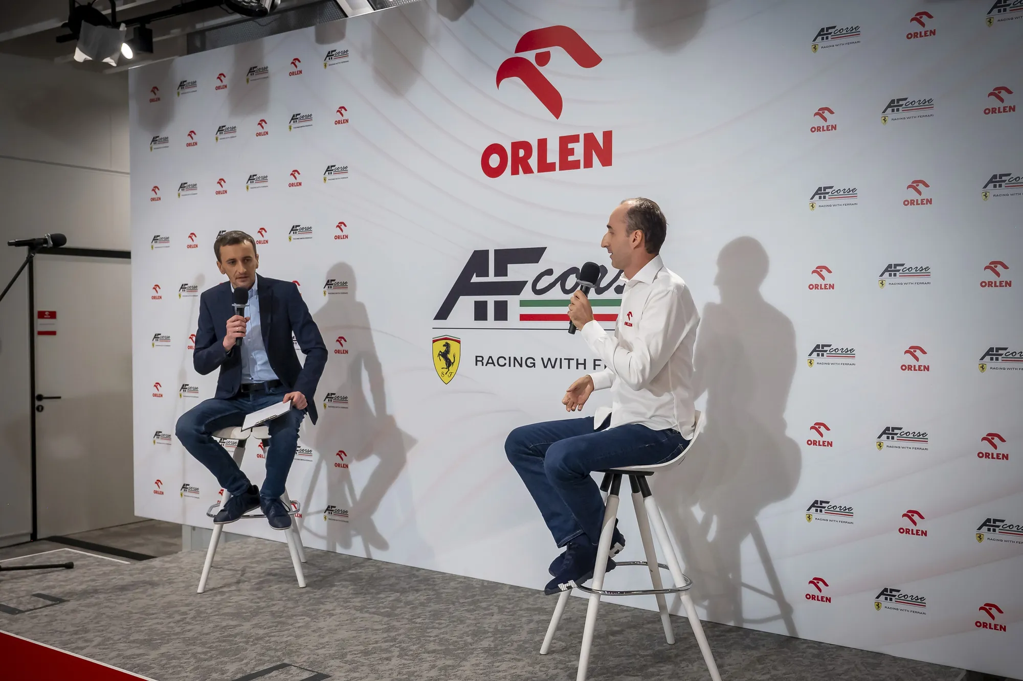 Robert Kubica udziela wywiadu na scenie konferencji prasowej ORLEN.