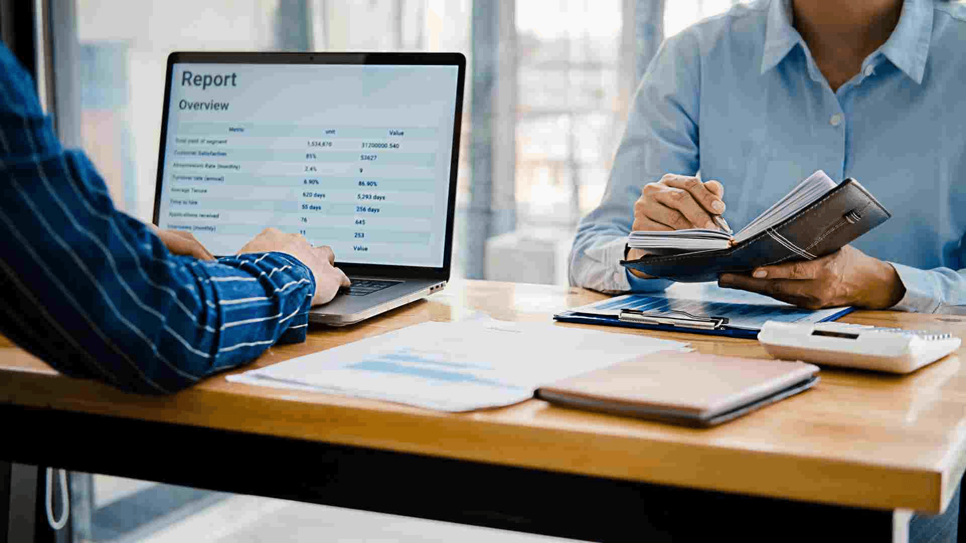 Two people discussing business report data - Business Report Writing