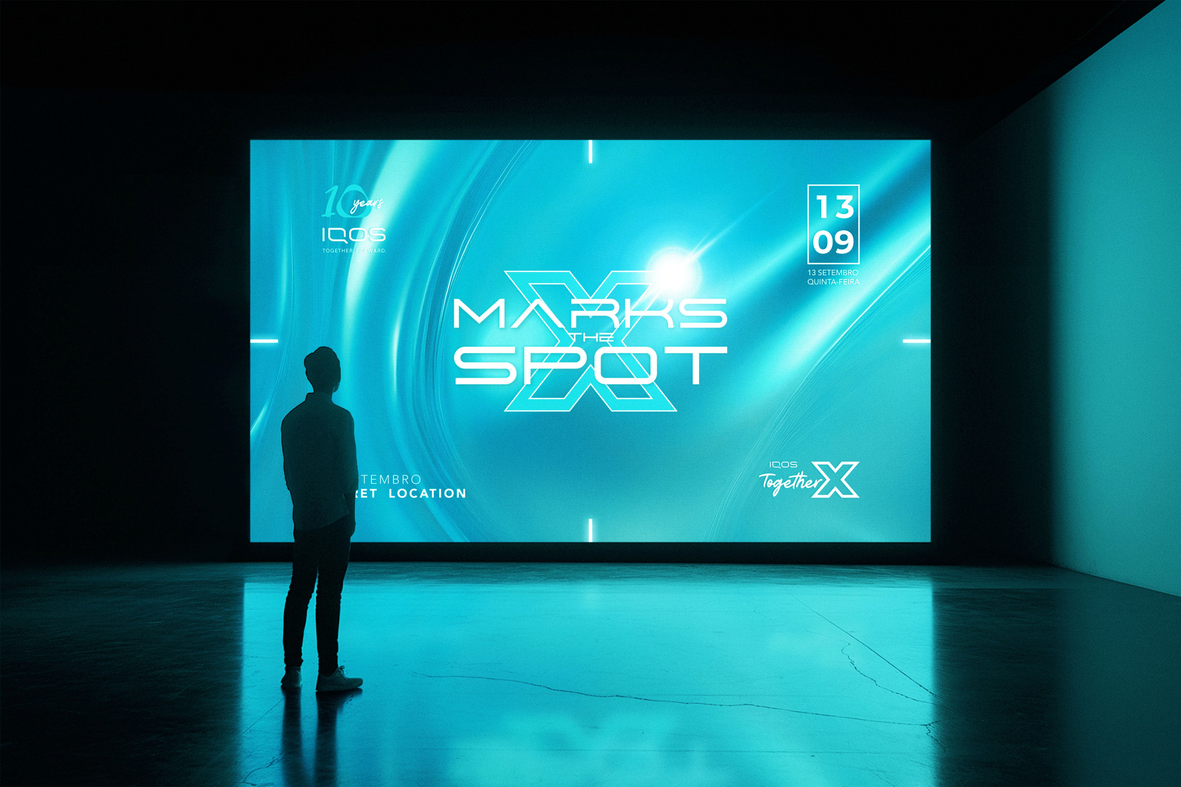 Immersive event screen design for the IQOS 10 Years celebration, showing the “Marks the Spot X” visual identity on a large LED wall with futuristic turquoise lighting and spatial branding.