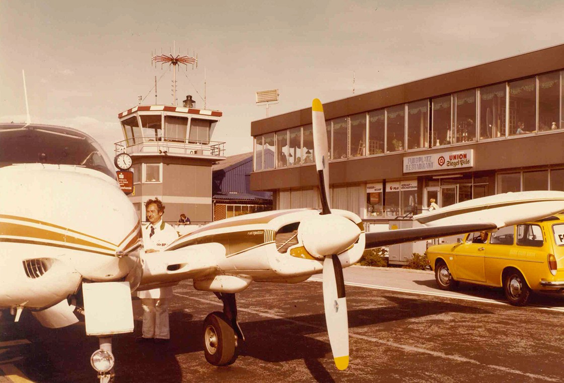 Kleines Propellerflugzeug steht vor Terminal am Flughafen Dortmund