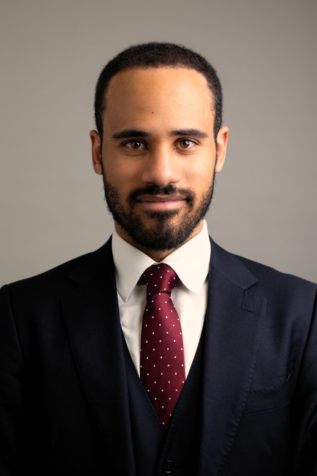 Man in dark suit, white shirt, and polka dot tie.