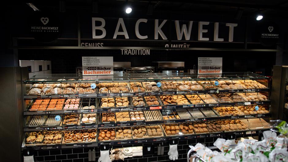 In der "Backwelt" können Kunden Erzeugnisse des niederbayerischen Familien-Bäckers Bachmeier finden. Die Beschriftung an der Wand rückt "Genuss", "Tradition" und "Qualität" in den Fokus.