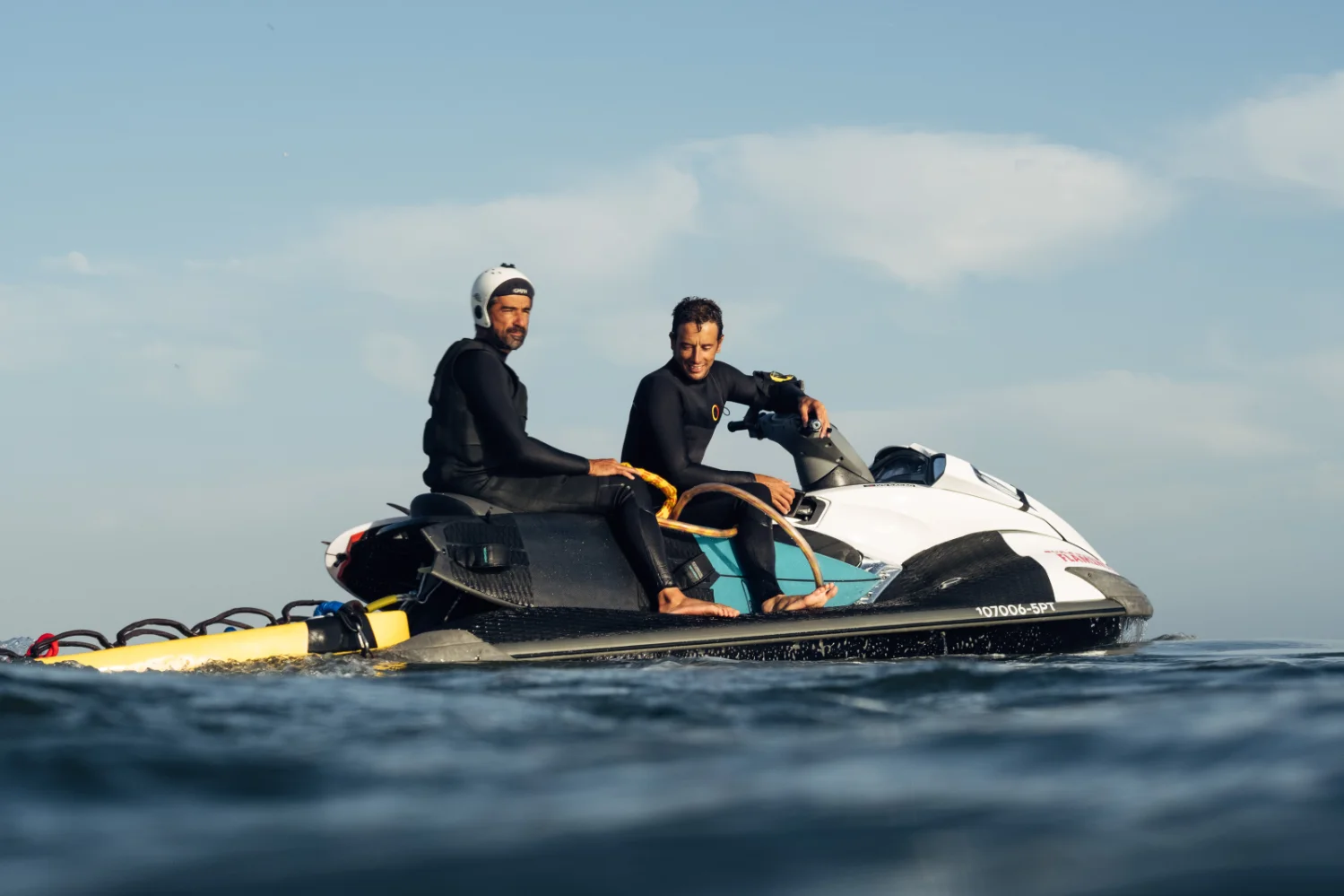 a surfer and a jet ski operator looking for a big wave
