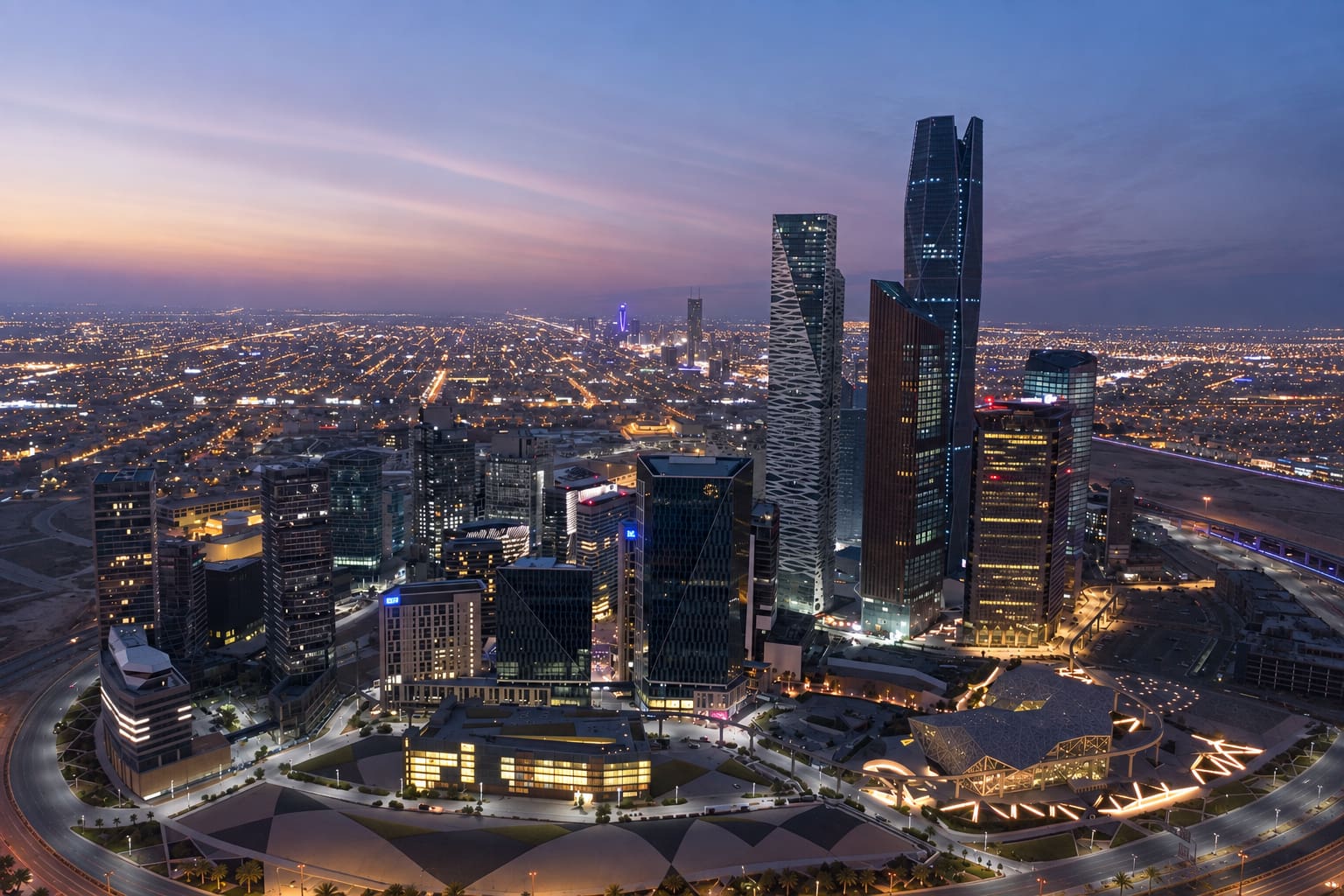 Aerial view of KAFD in Riyadh showing modern high-rise buildings, illuminated streets, roads and surrounding urban development&nbsp;