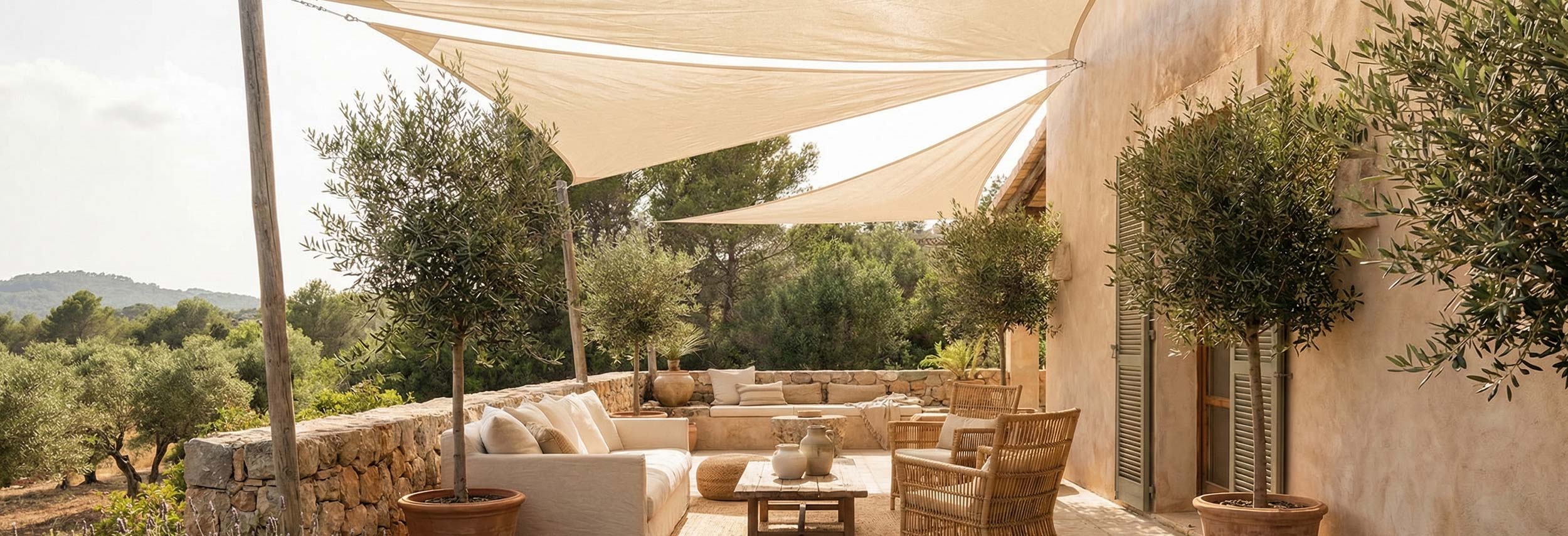 jardin mediterraneo con sillones y velas de sombra