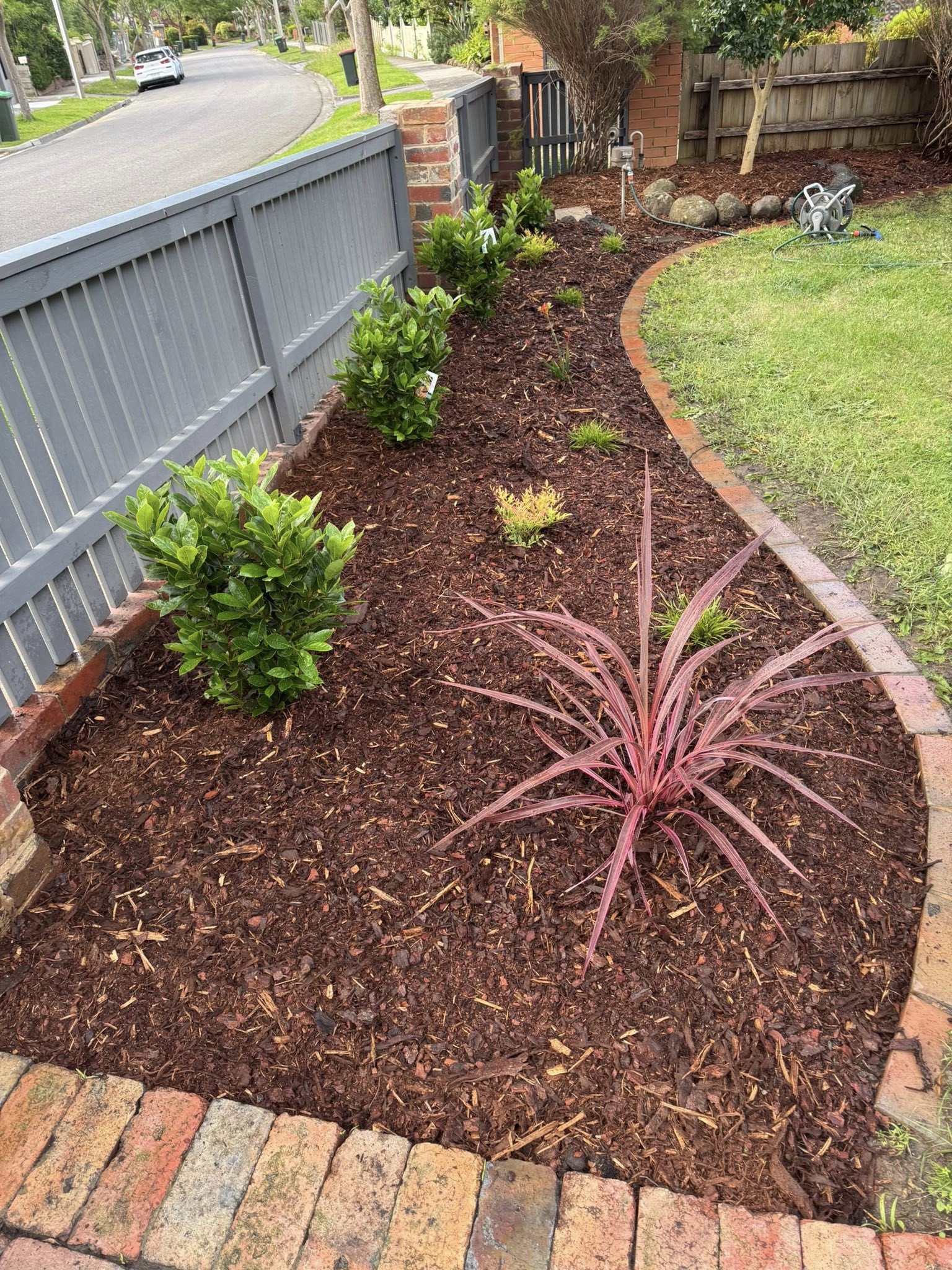 A garden bed weeded, edged and topped with fresh mulch by BCW