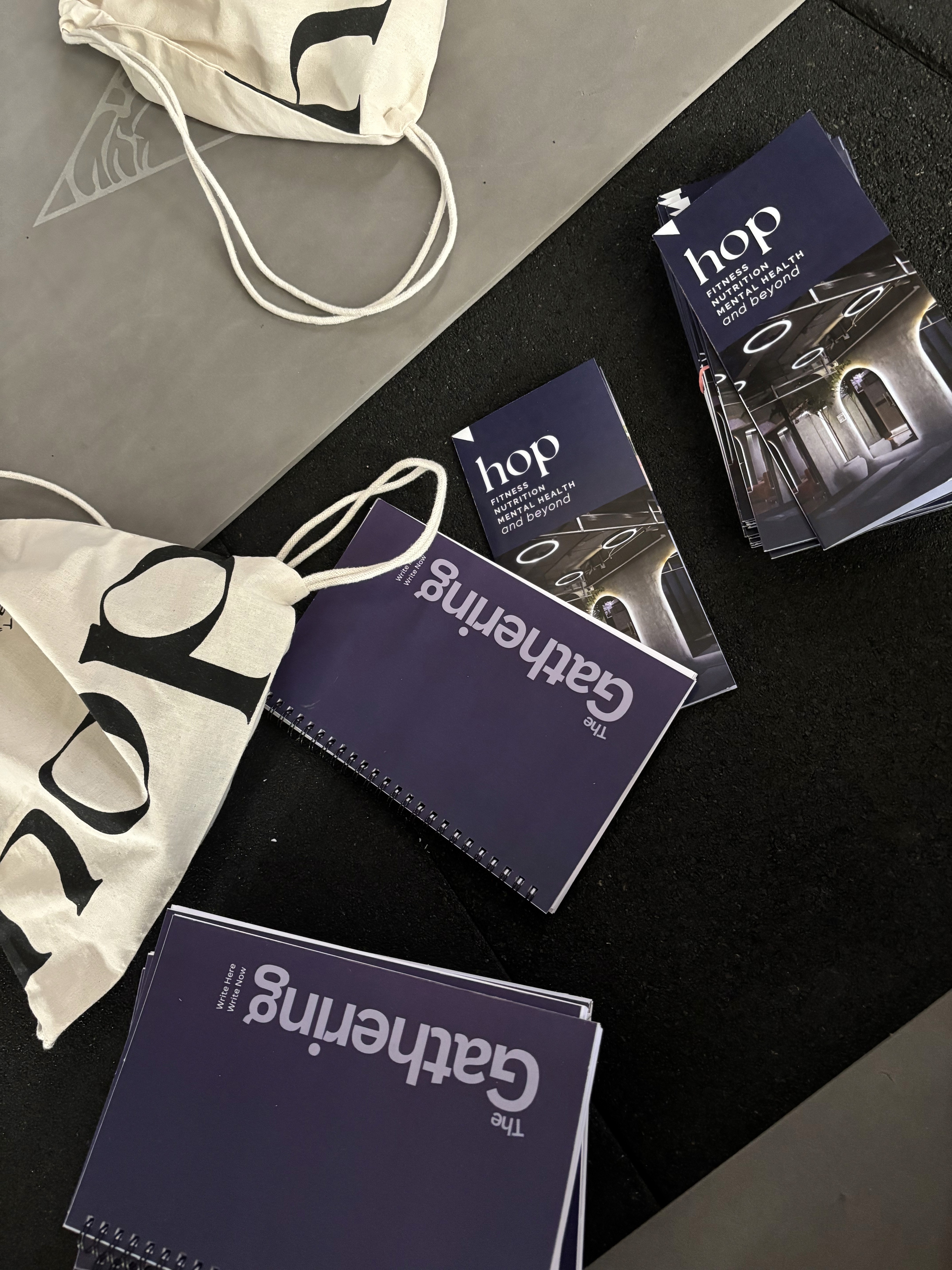 A blank white card resting on a softly draped rust-colored fabric atop a beige quilted surface.