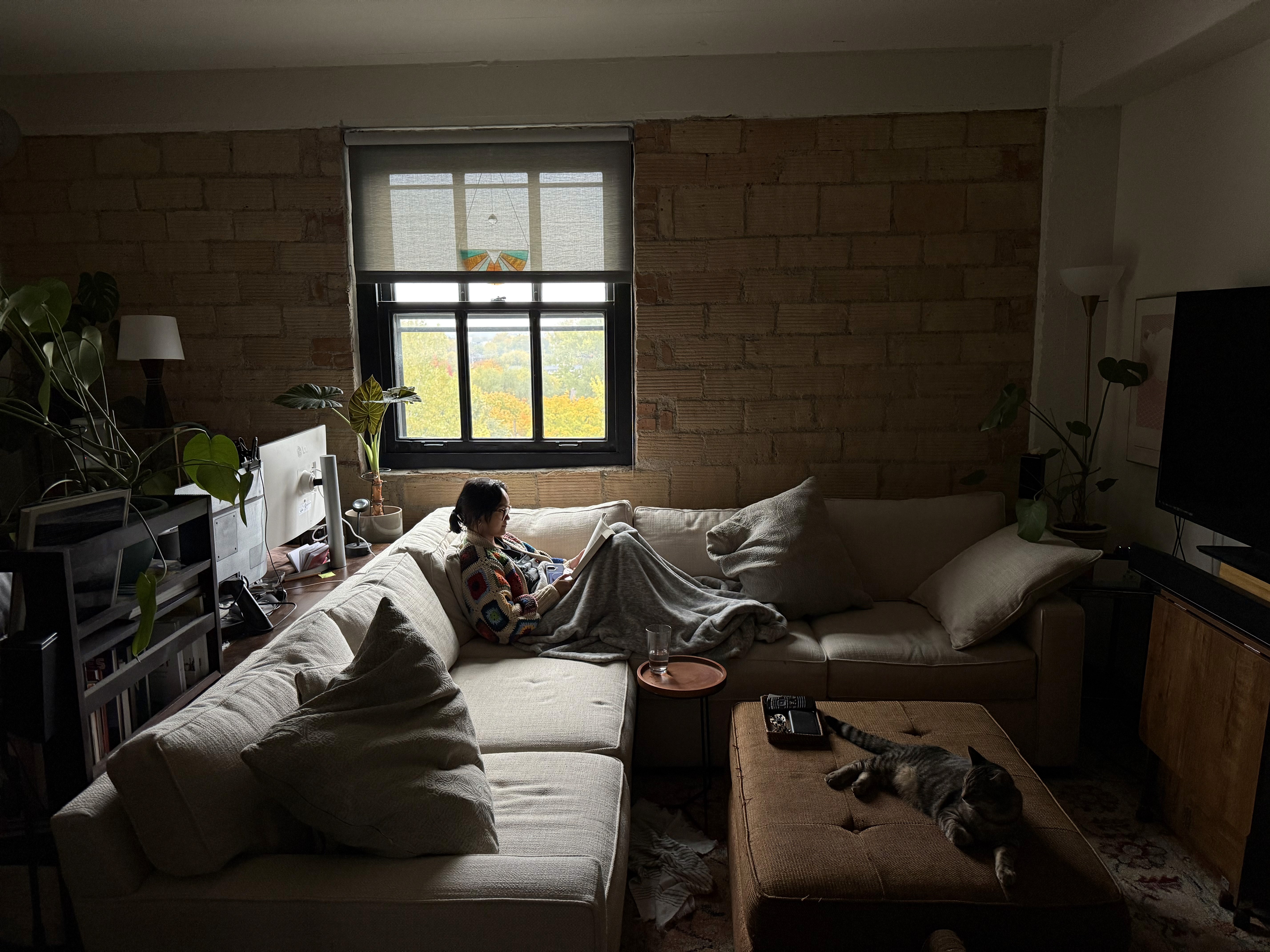 Four diverse professionals collaboratively working on a laptop, with one person pointing at the screen while others observe.