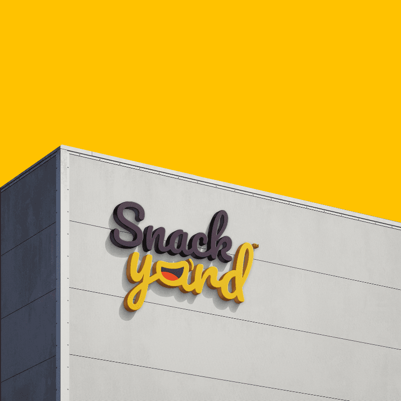 Building exterior with a large “Snack Yard” logo in black and yellow lettering against a yellow background. Bold text beside the image reads “300+ Dark stores,” highlighting the company’s extensive network of distribution hubs.