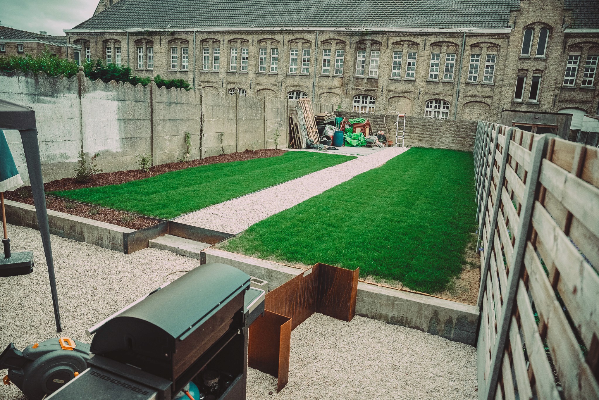 Een schaduwrijke tuin met hoge bomen, varens en schaduwminnende planten, ontworpen door Intergreen Tuinen.