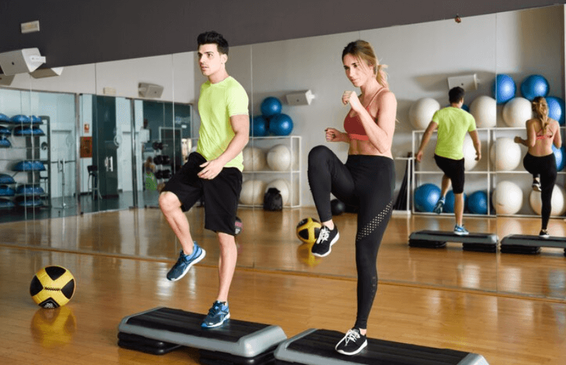 Man and woman performing step ups as a low-impact activity to increase bone density.