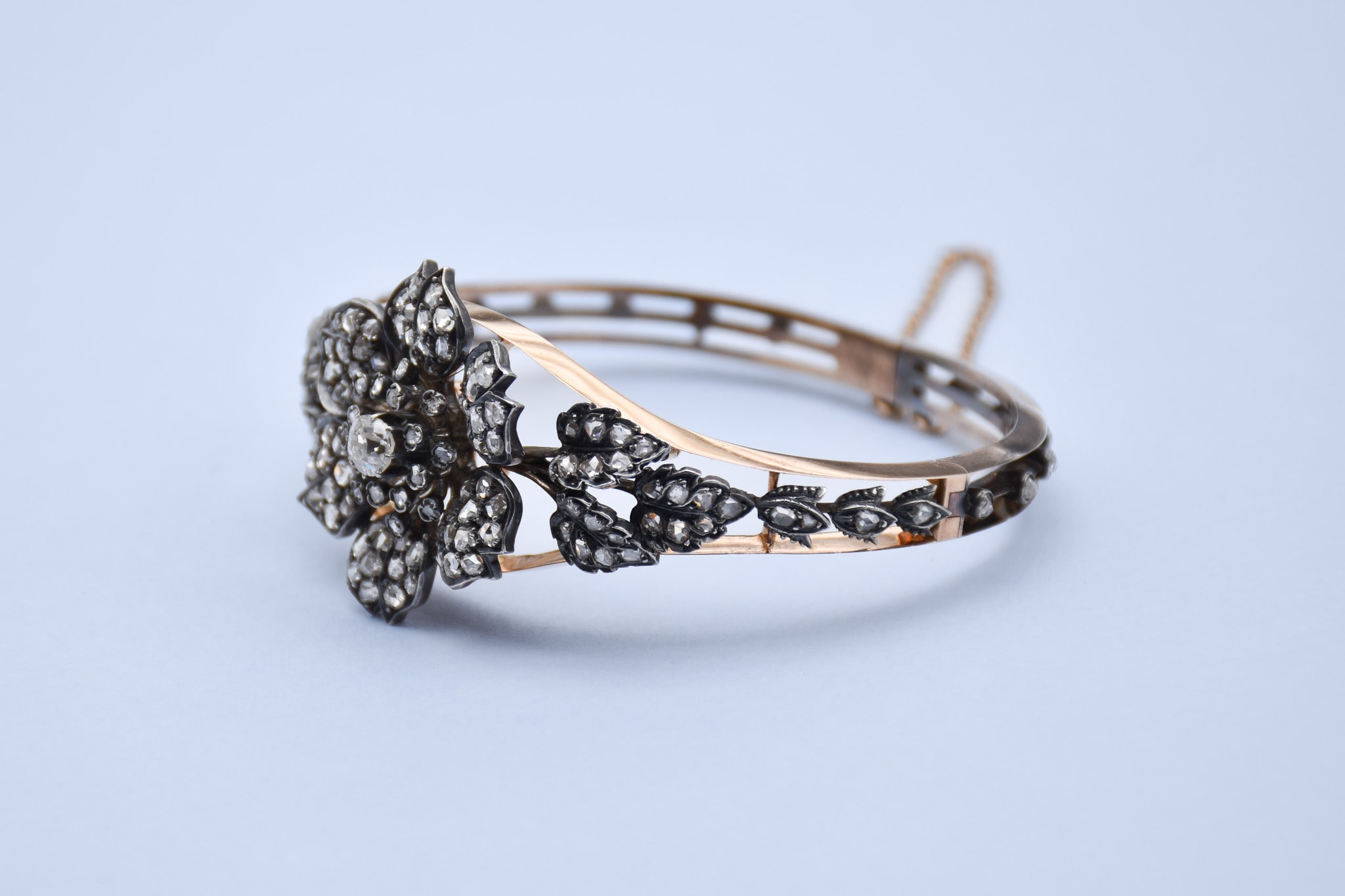 Vue de profil d'un bracelet en or et argent représentant une fleur d'églantier en diamants