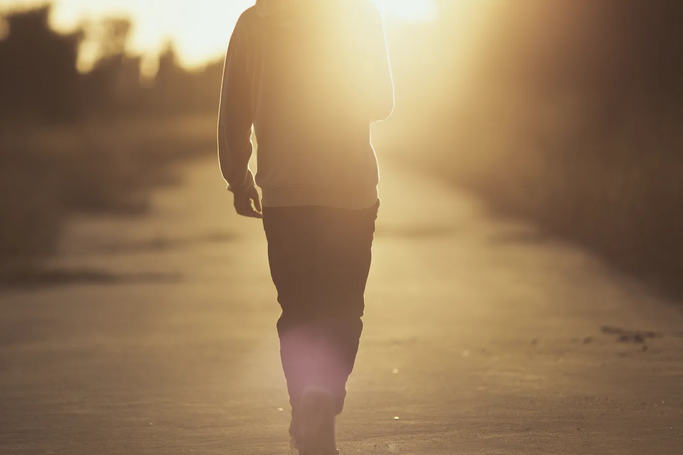Man walking into sunset