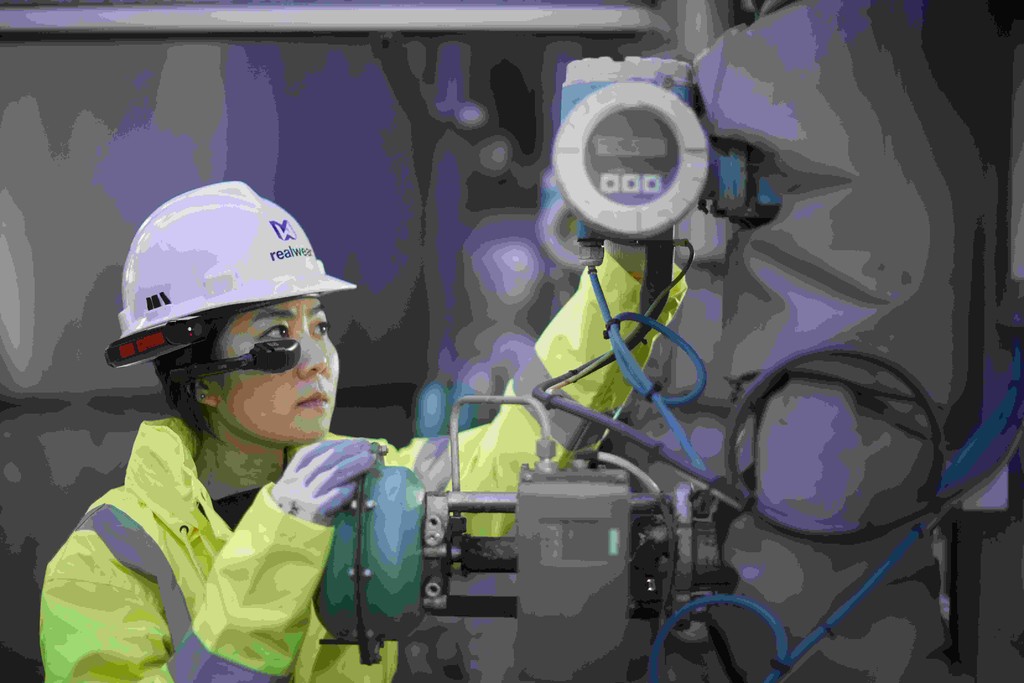 An engineer fixing machinery at a processing facility