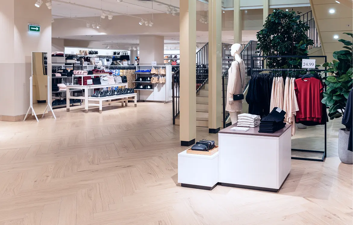 Moderner Verkaufsraum eines Bekleidungsgeschäfts mit Kleidung und Regalen.