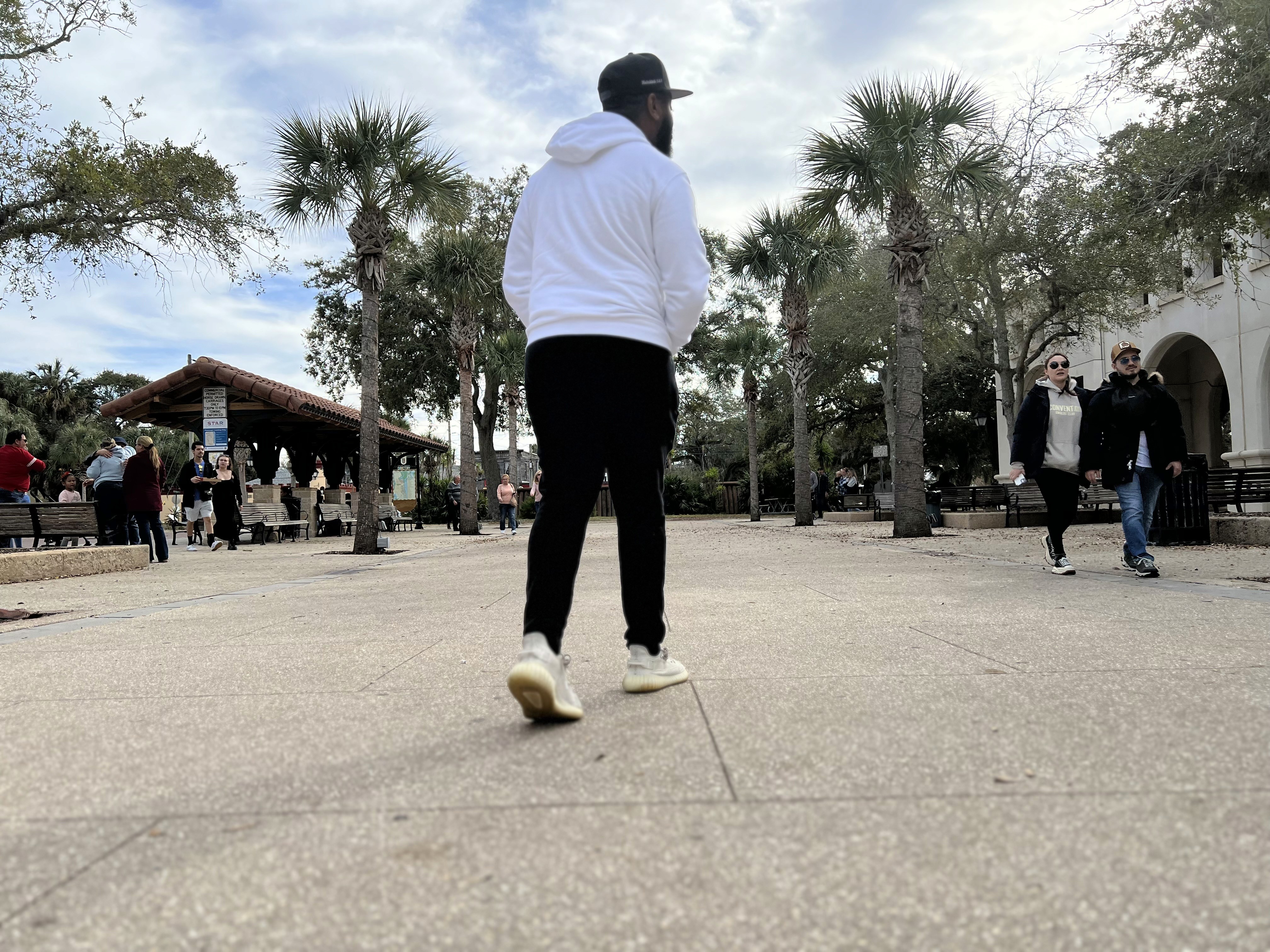 a group of people walking on a sidewalk