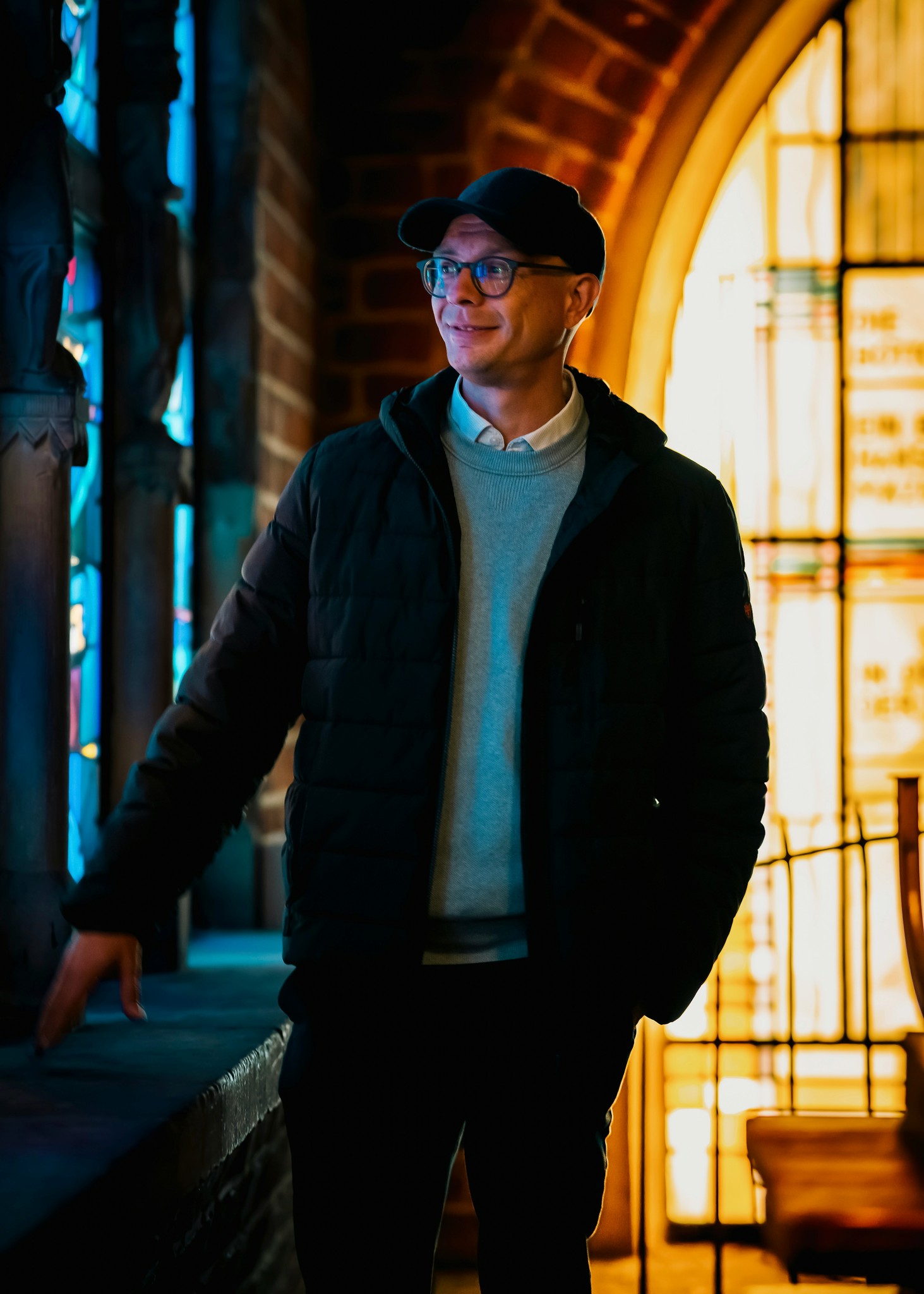 A man standing in front of a stained glass window