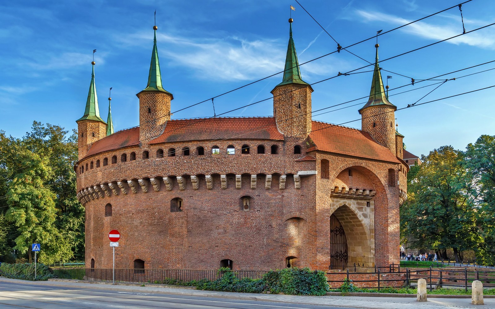 在电动车导览城市游中，参观克拉科夫巴比肯及绿色尖顶建筑。