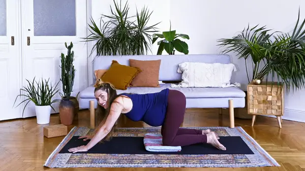 Pregnant woman in a supported wide-legged side stretch – Day 2 mood-boosting prenatal yoga class with prop-supported poses to release tension safely