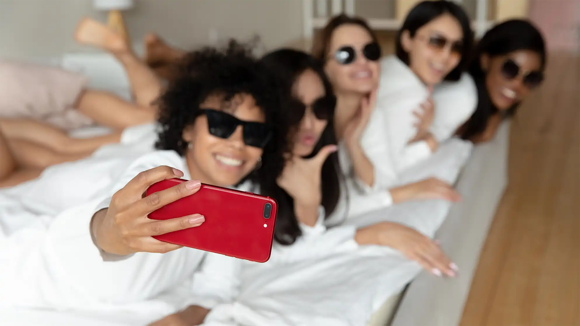 Five women at a bridal shower taking a selfie with a red phone