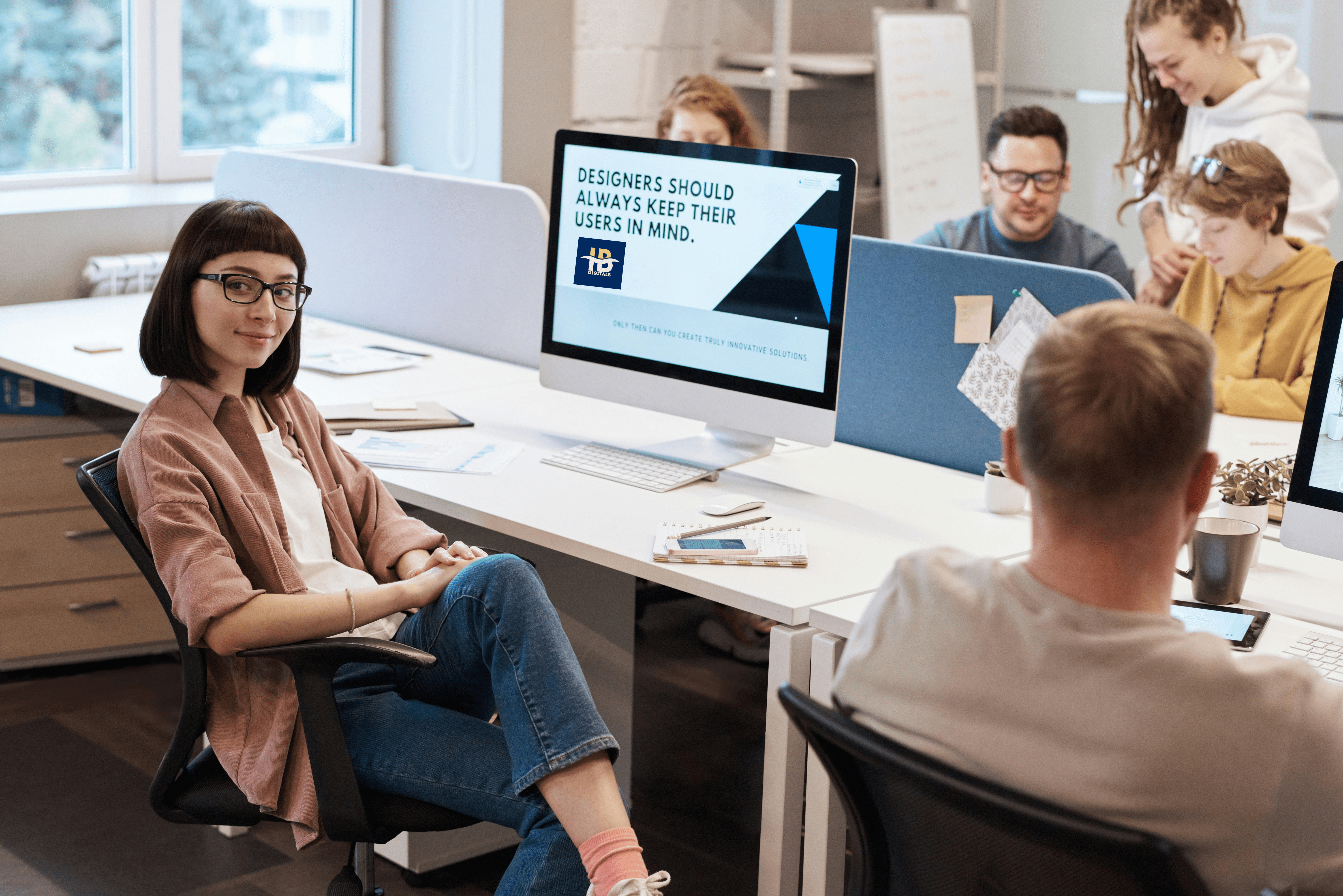 Lady sitting in front of a desktop with ib digitals logo